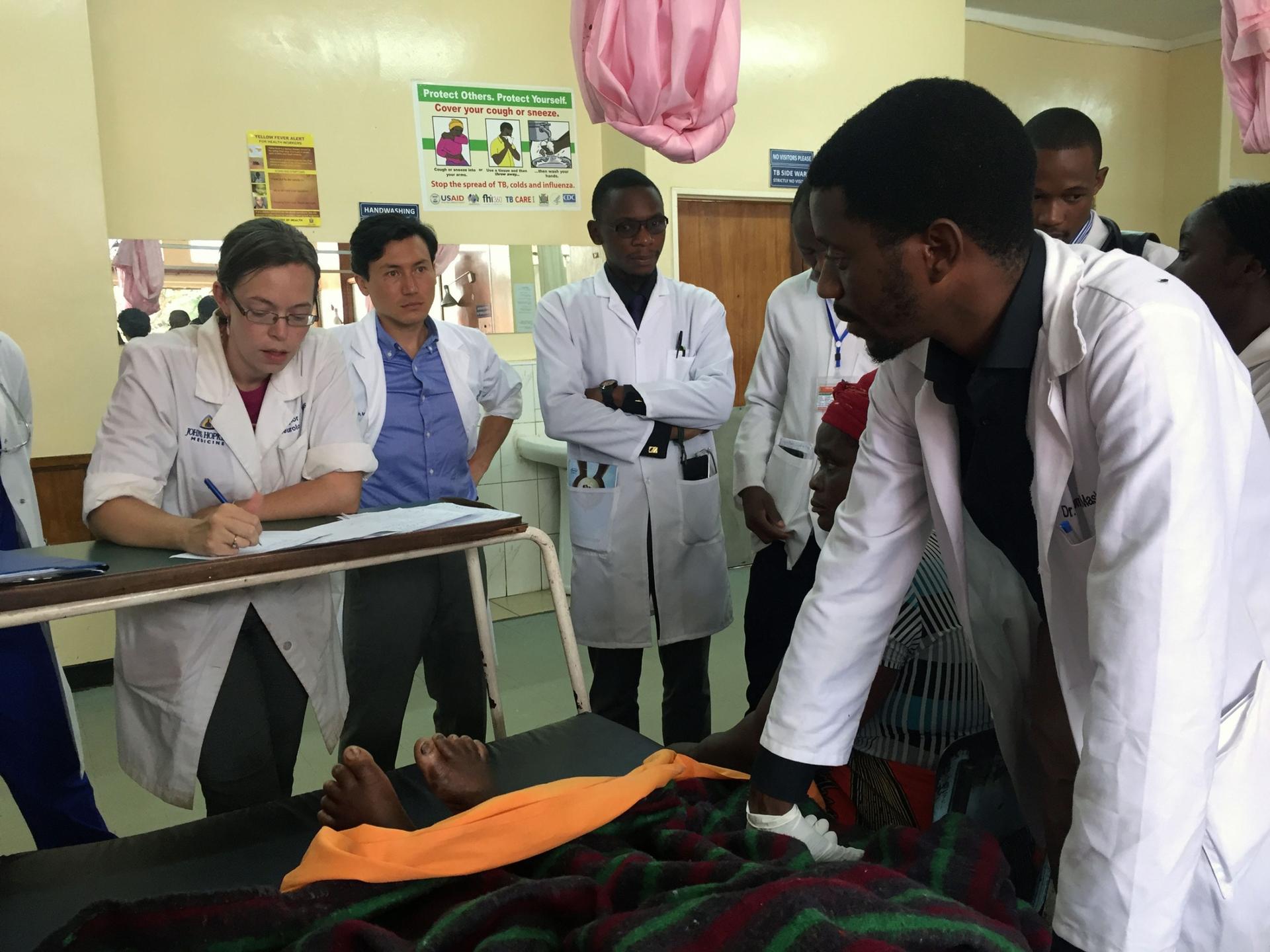 Neurologist Deanna Saylor (far left) evaluates patients at University Teaching Hospital during rounds with the neurology residents. Dr. Mashina Chomba (far right) is among them and is one of the first Zambian neurologists trained through the new program.
