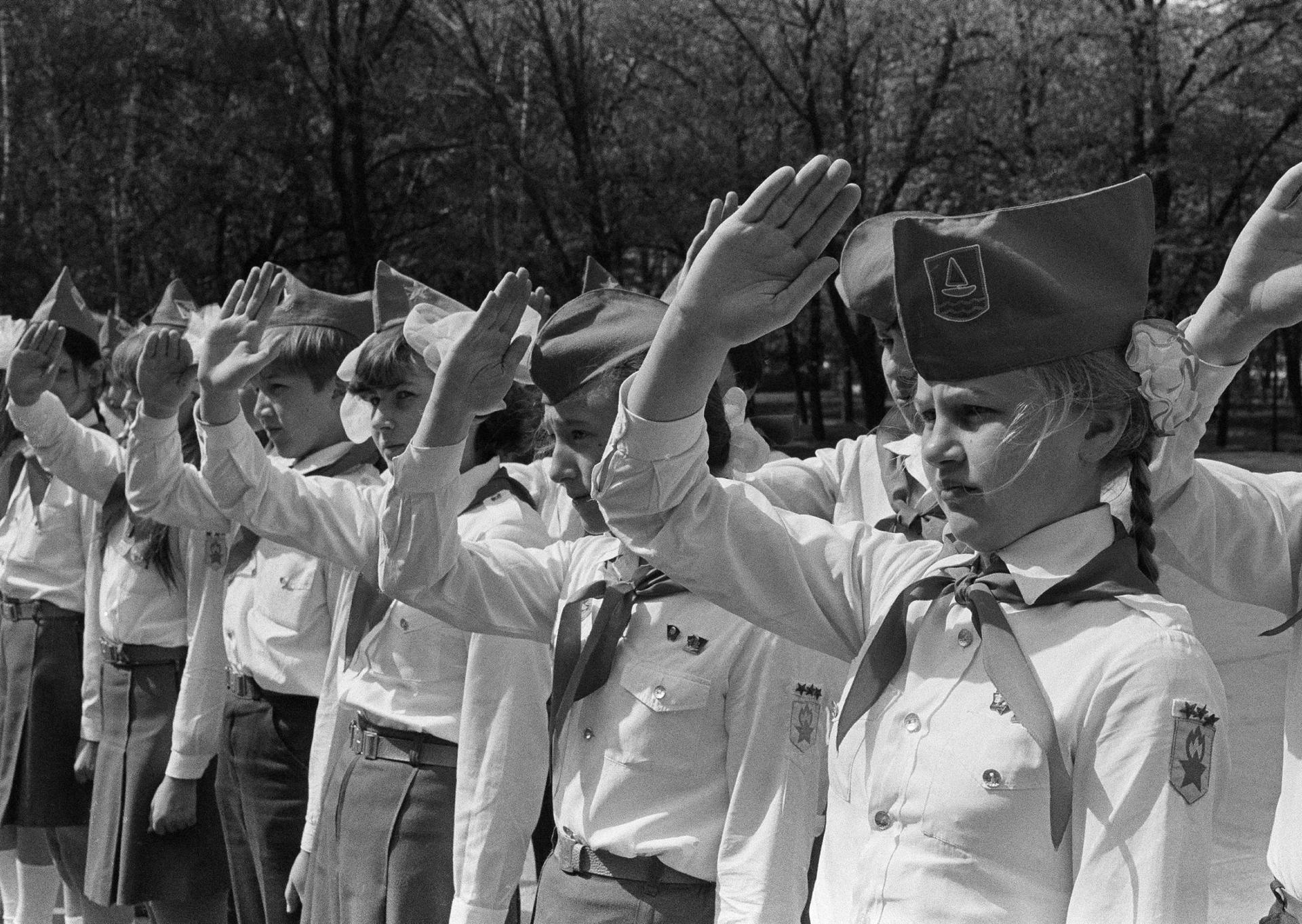 Members of the Pioneers, a Communist youth organization, give the Pioneer salute at ceremonies marking the organization's anniversary, May 19, 1981. 