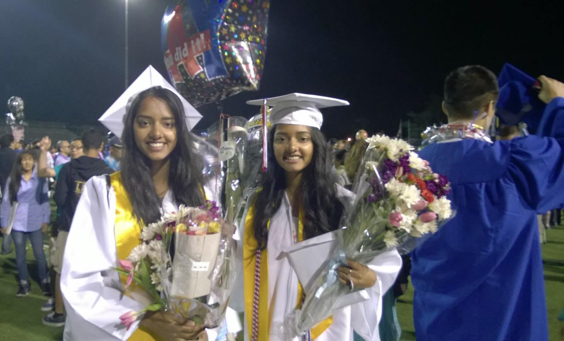 two girls wearing graduate robes