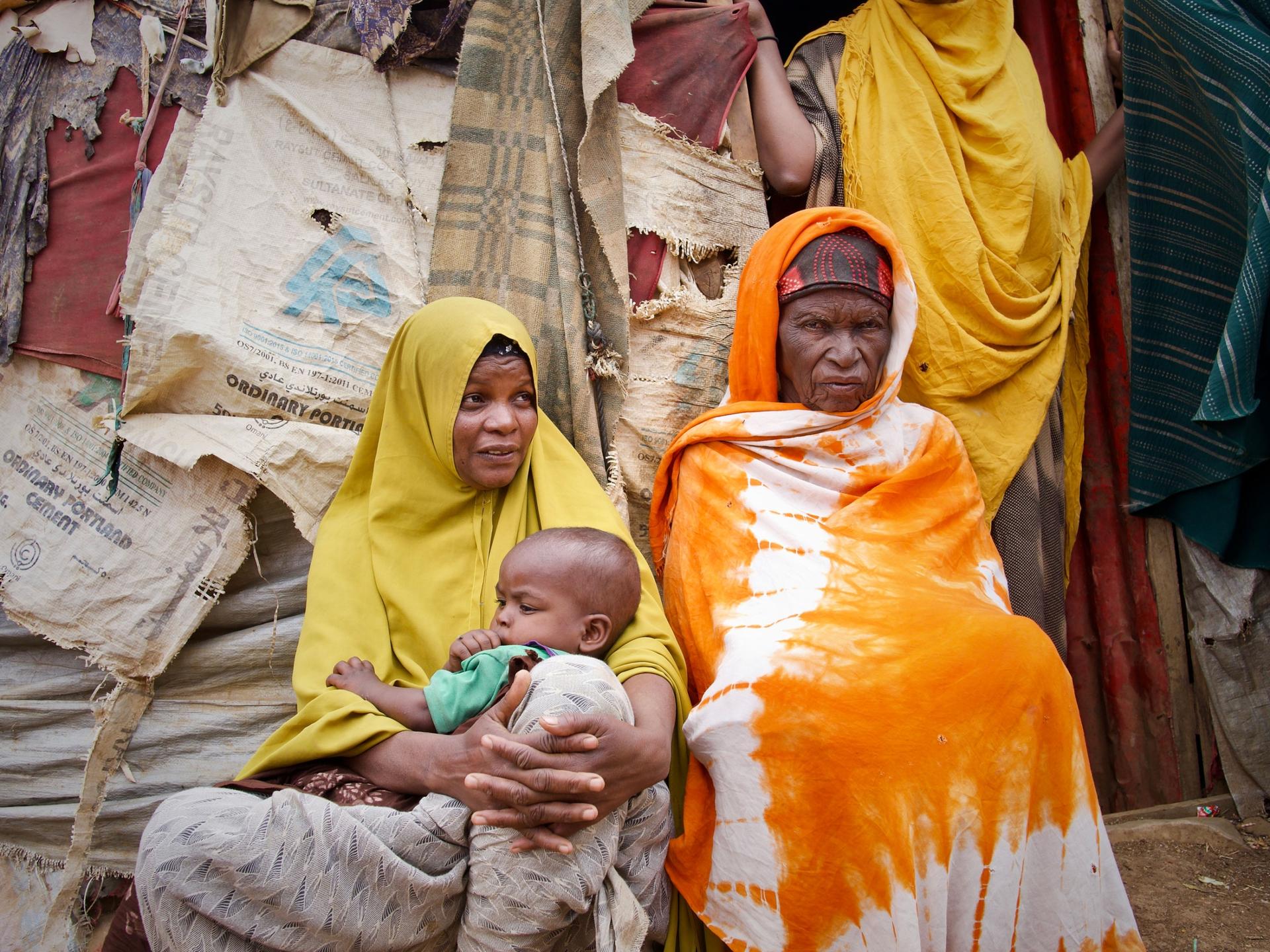 A family sits outside their makeshift camp for internally displaced people in Baidoa, Somalia. A million people have been dispalced by ongoing drought. 