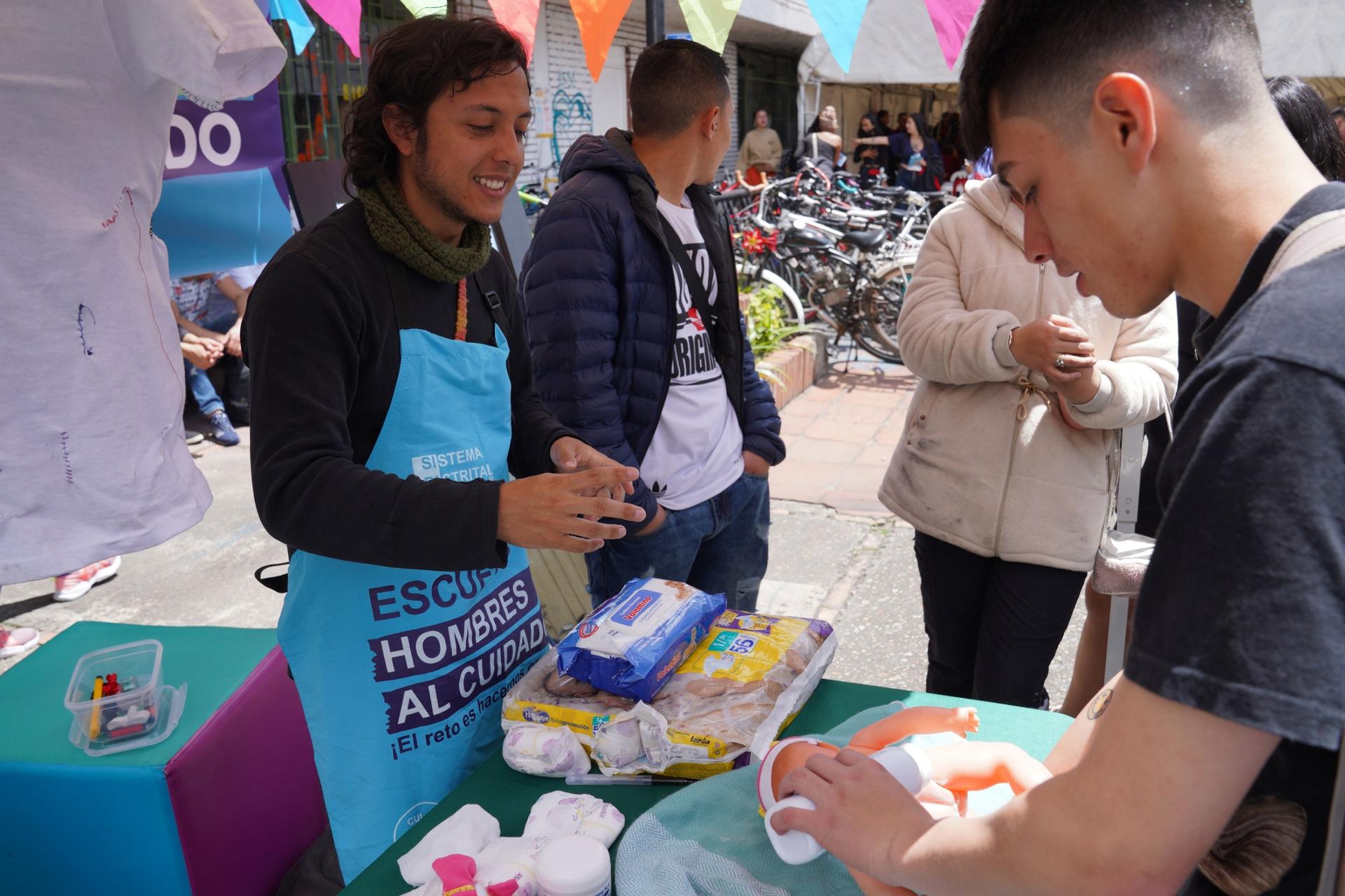 At a job fair in Bogotá, Nicolas Londoño showed groups of young men how to change a baby's diapers.  