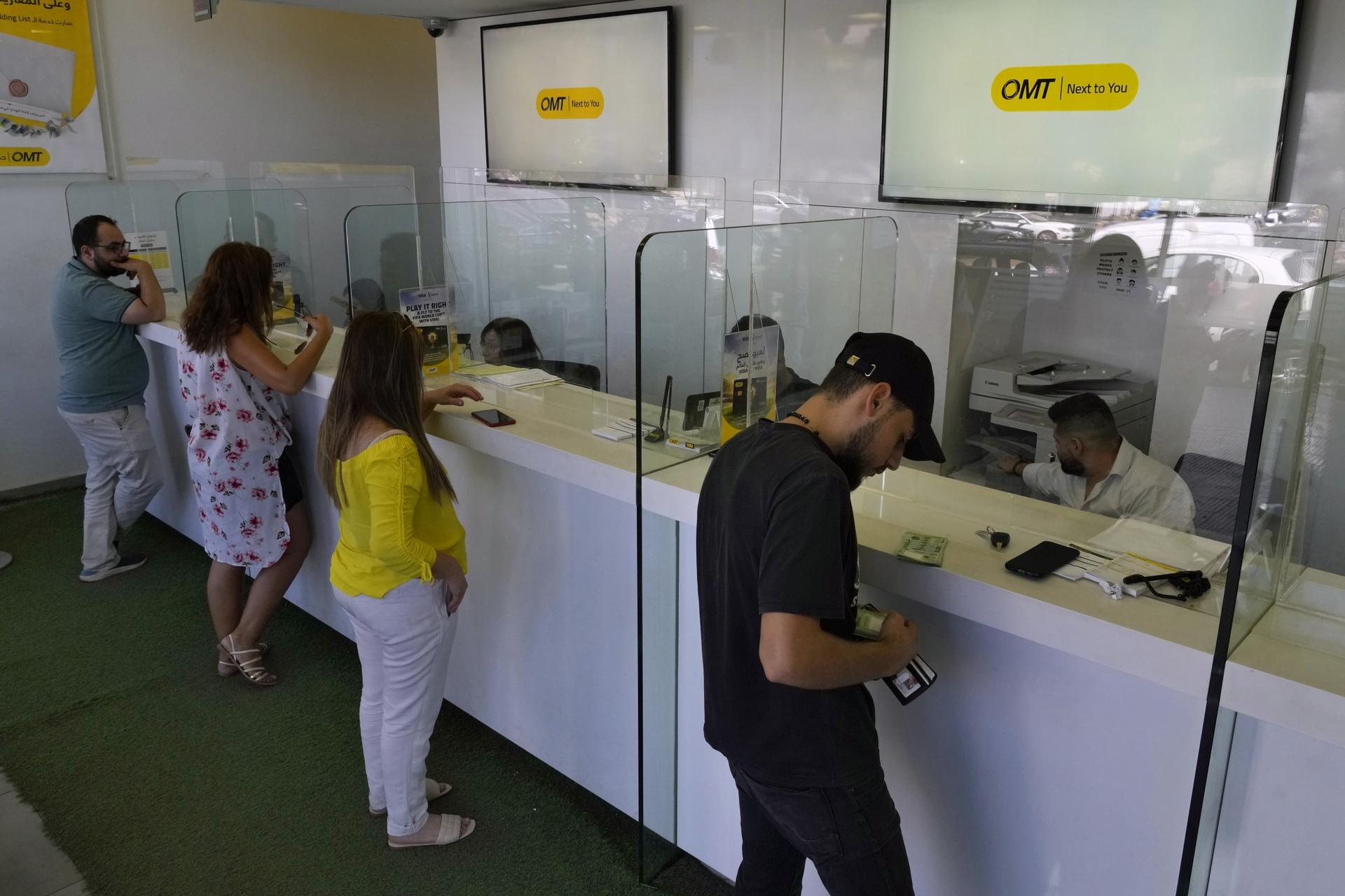 People stand inside the money transfer offices of Western Union and OMT in Beirut, Lebanon