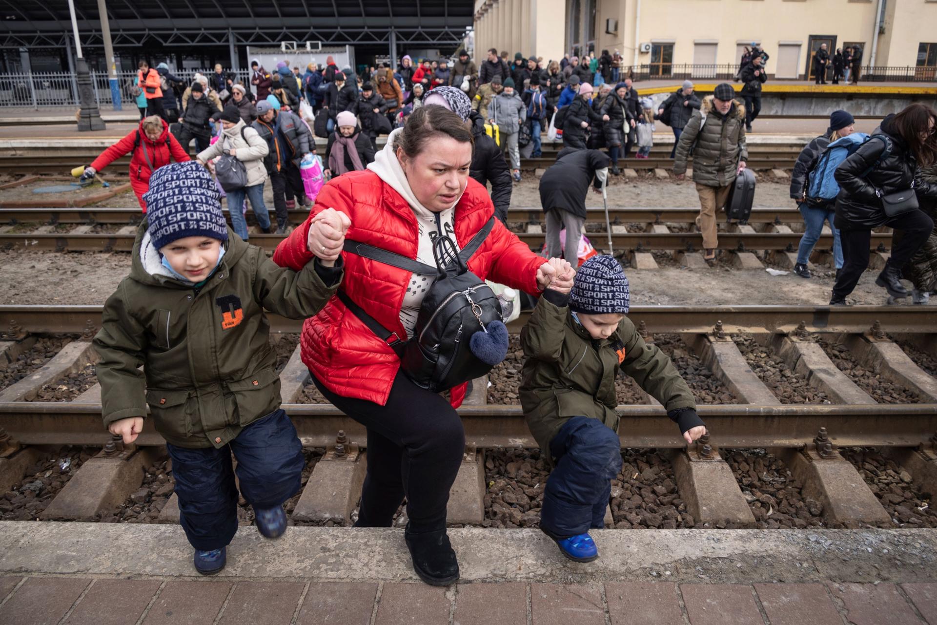 People, mostly women and children, try to get onto a train bound for Lviv, at the Kyiv railway station, Ukraine, Friday, March 4, 2022. 