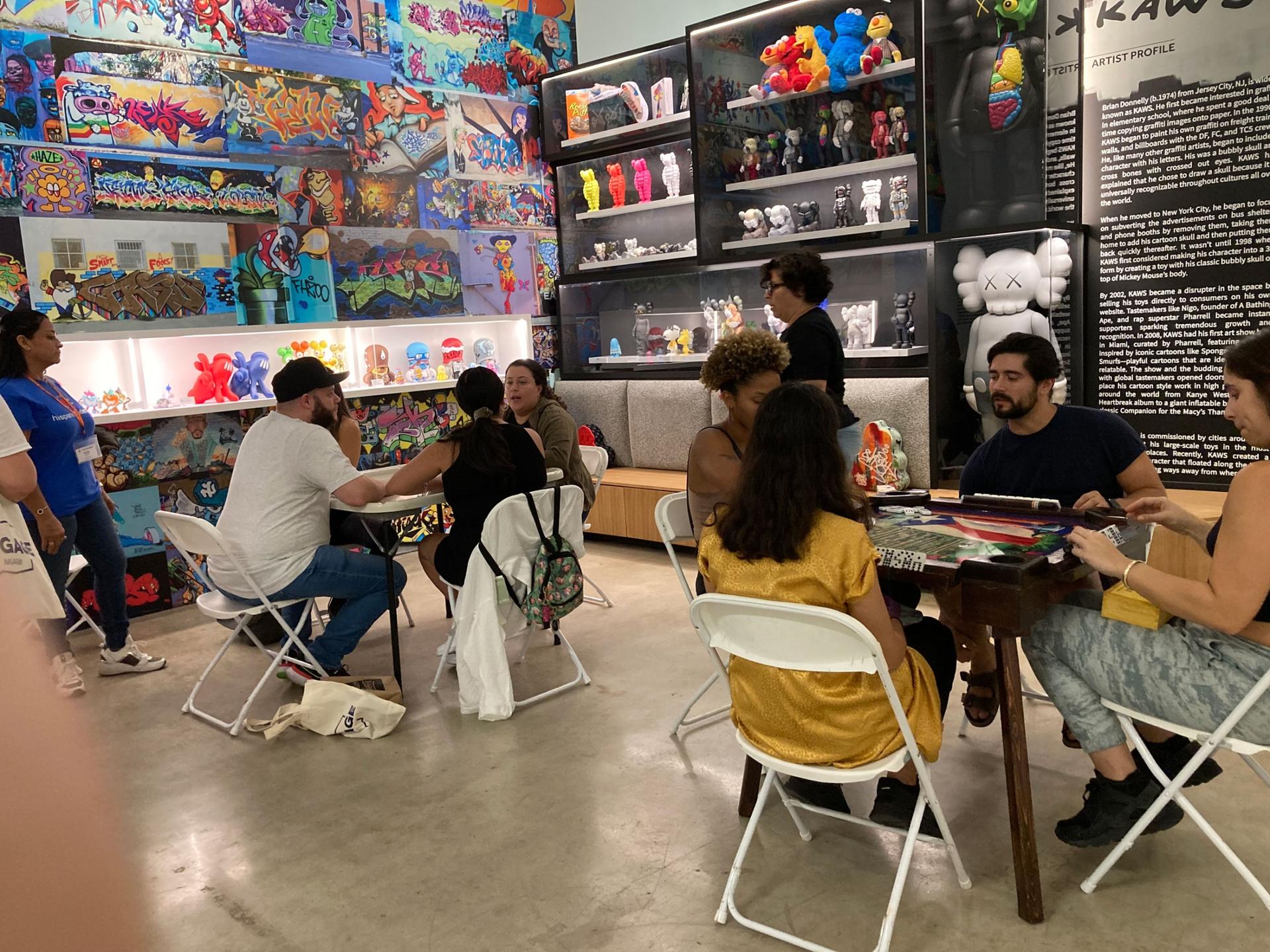 People gather to play dominoes, Cuba's national past-time, at the Museum of Graffiti in Miami. 