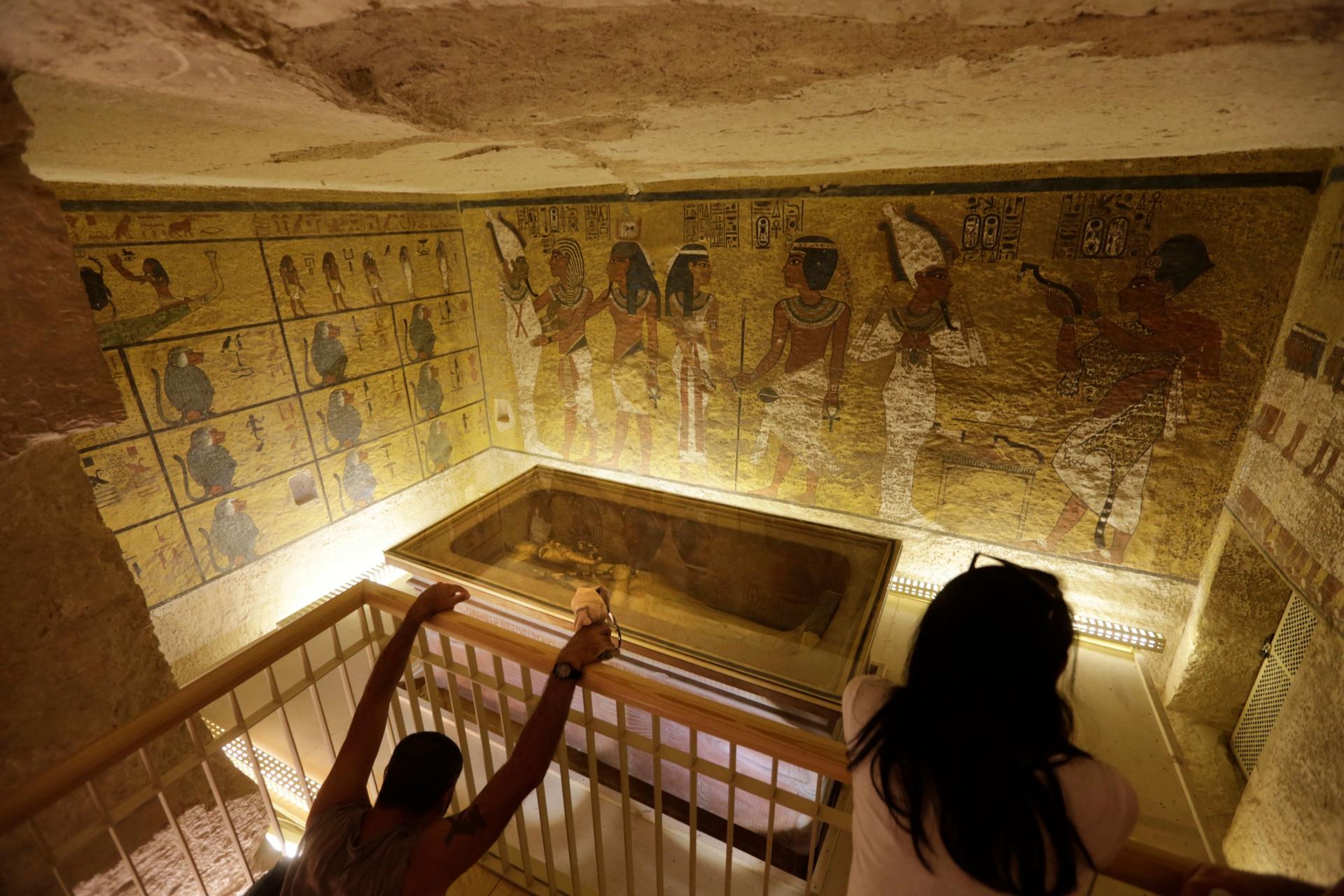 In this Thursday, Nov. 5, 2015, file photo, tourists look at the tomb of King Tut as it is displayed in a glass case at the Valley of the Kings in Luxor. 