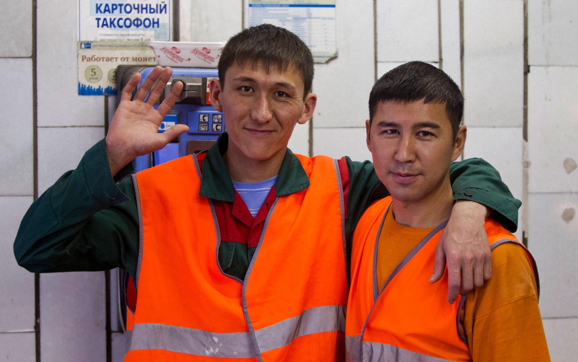 In this Aug. 27, 2012, photo, Uzbekistan natives and subway janitors Kushan, right, and Umid pose for a photo in Moscow.