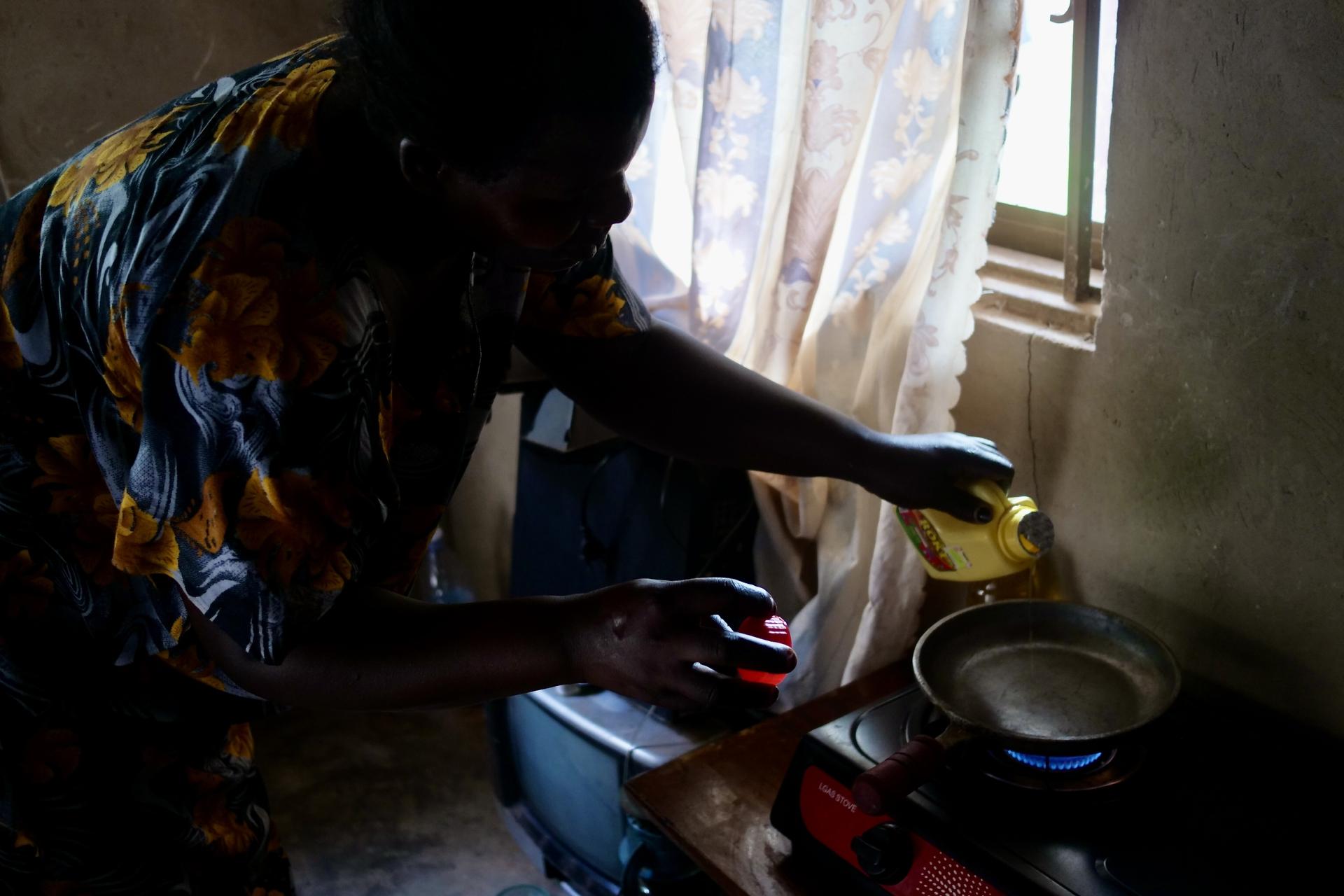 Noowe Kazo shows off the new gas stove she recieved from the government, Bukasa, Uganda, November 2022.
