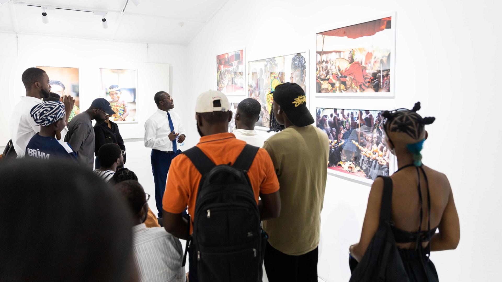 Paul Ninson takes some visitors through the Asante chieftaincy-themed inaugural exhibition at the Dikan Center.