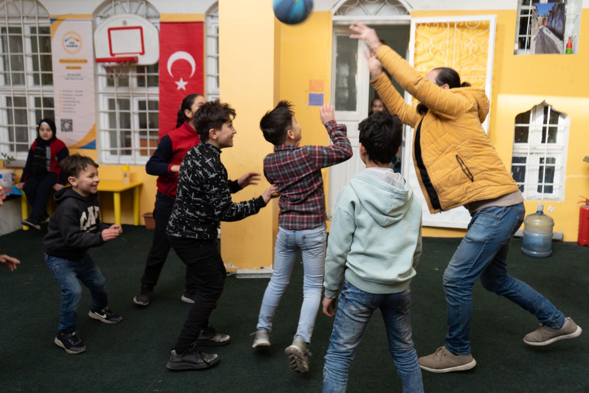 Mustafa Kara Ali plays a game with students at Kids Rainbow. 