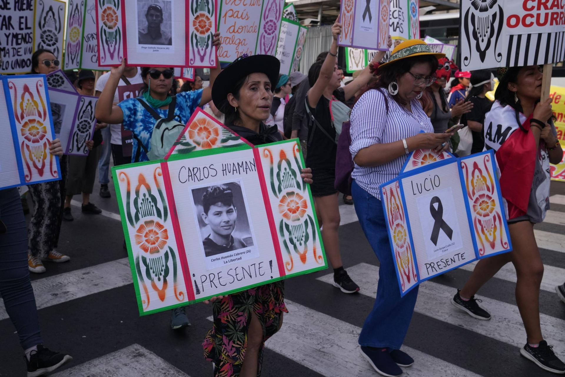 Protesters in Lima carry signs with the photos of demonstrators who have been killed. 
