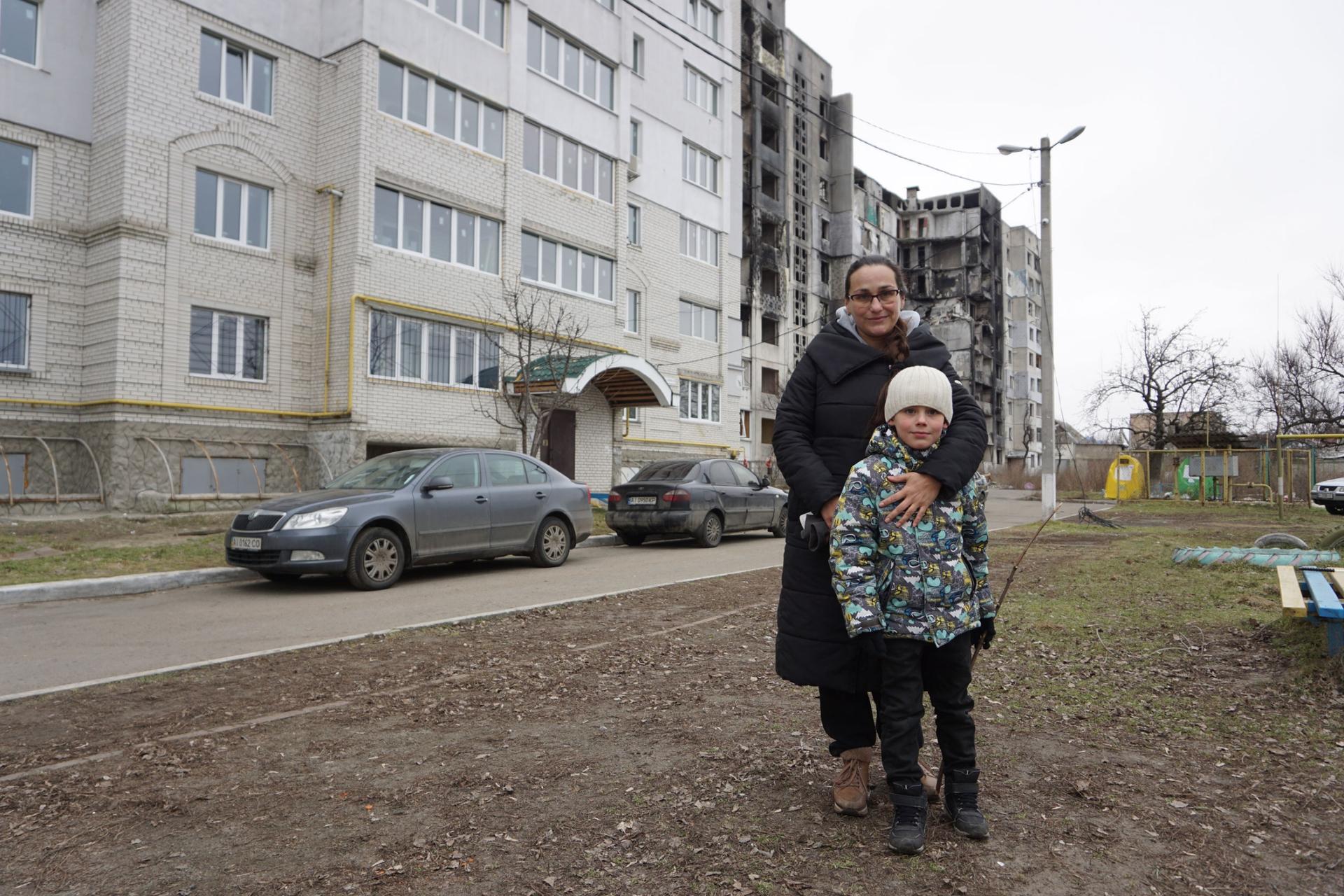 Olga Pred and her son Mikhail stand near their house on Central Street in Borodyanka, a Kyiv suburb.