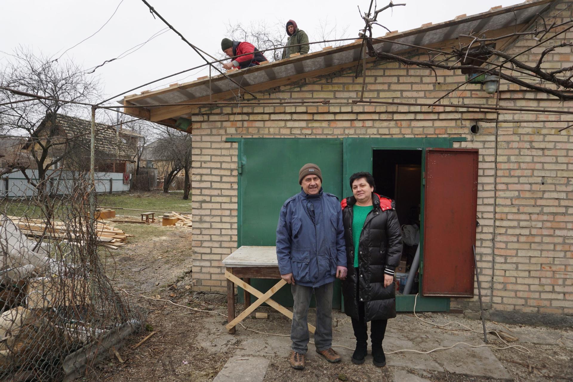 Yuriy Pysarchuk and his wife Valentina, live on Vokzal'na St in Bucha. Workers are fixing their rooftop.