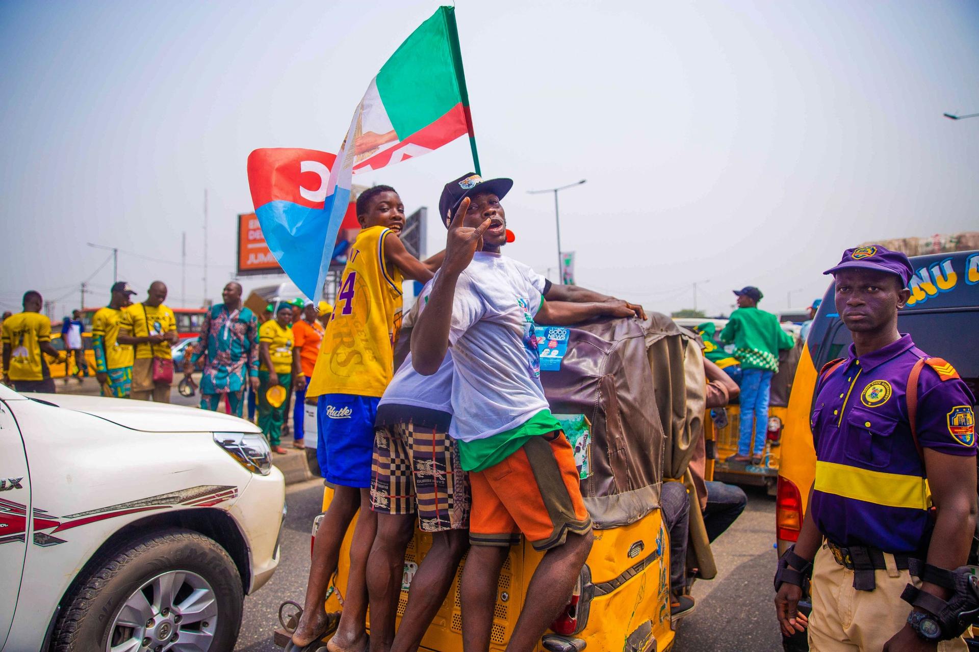 Supporters of Bola Ahmed Tinubu, the presidential candidate of the All Progressives Congress, Nigeria ruling party, rides on a rickshaw outside the venue of an election campaign rally at the Teslim Balogun Stadium in Lagos Nigeria, Tuesday, Feb. 21, 2023.