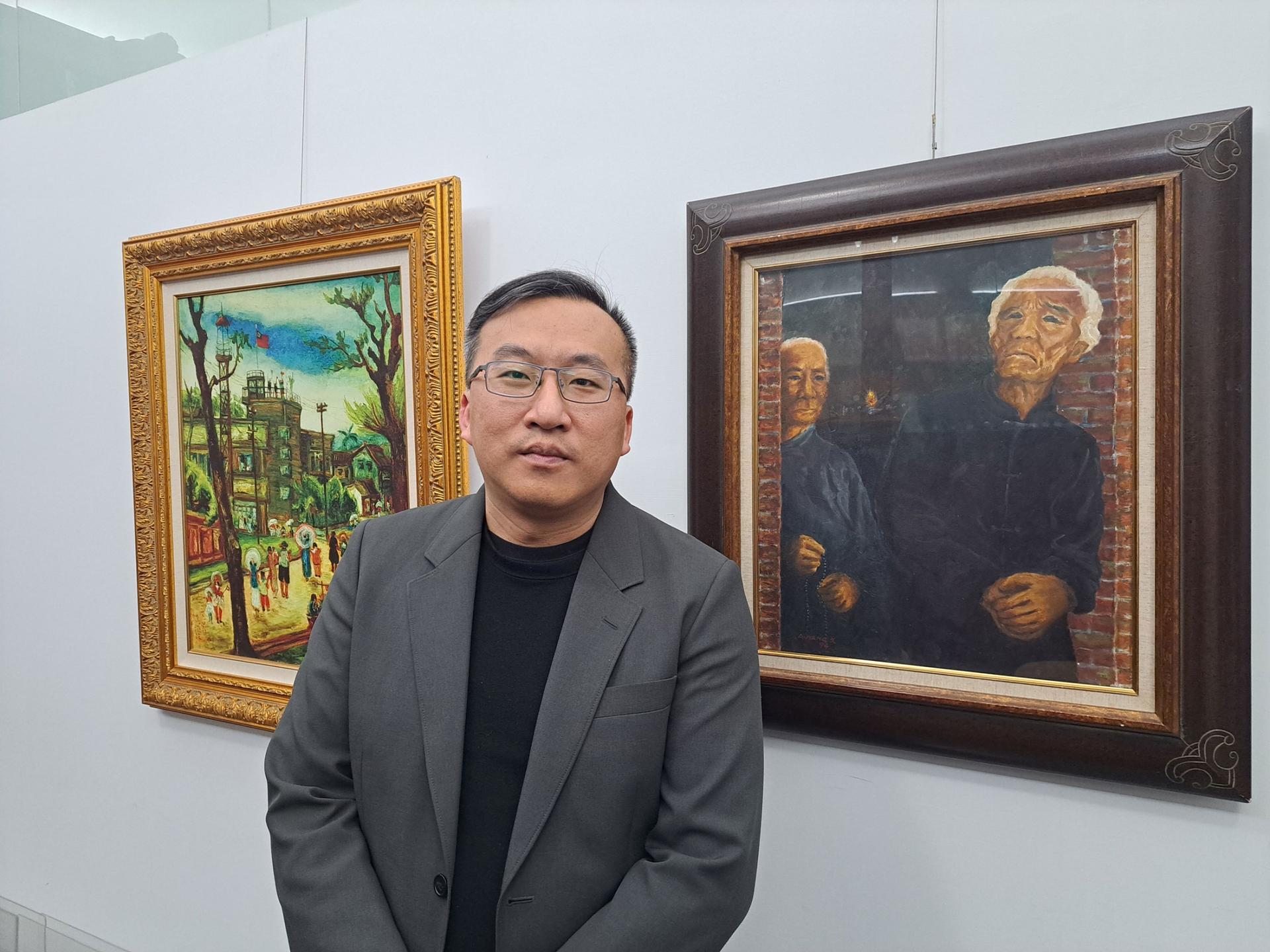 Chen Chia-Hao, an associate research fellow at the National 228 Memorial Museum, stands next to famous paintings related to the 228 massacre. 