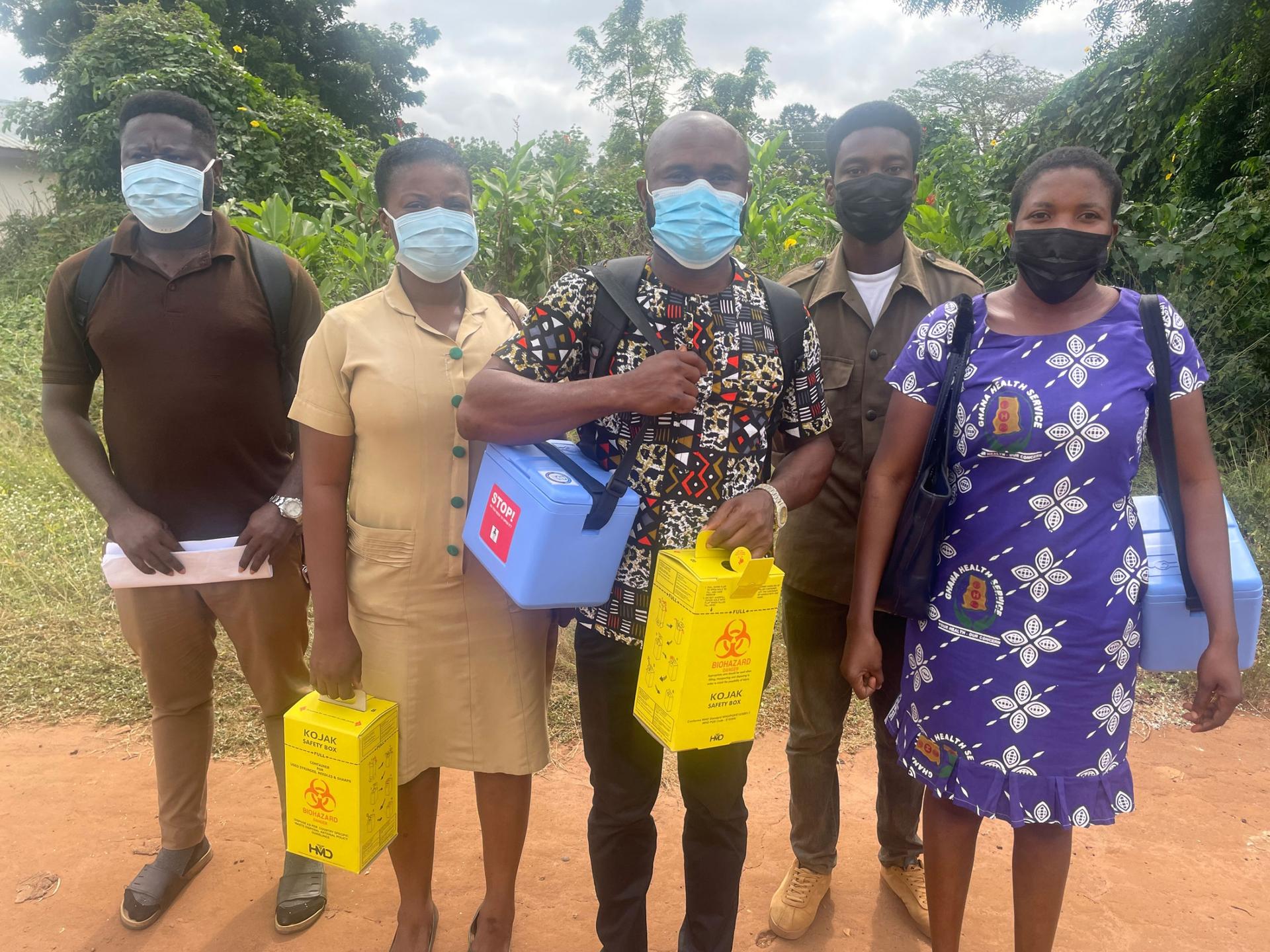 A group of health workers carry supplies for vaccination drives. 