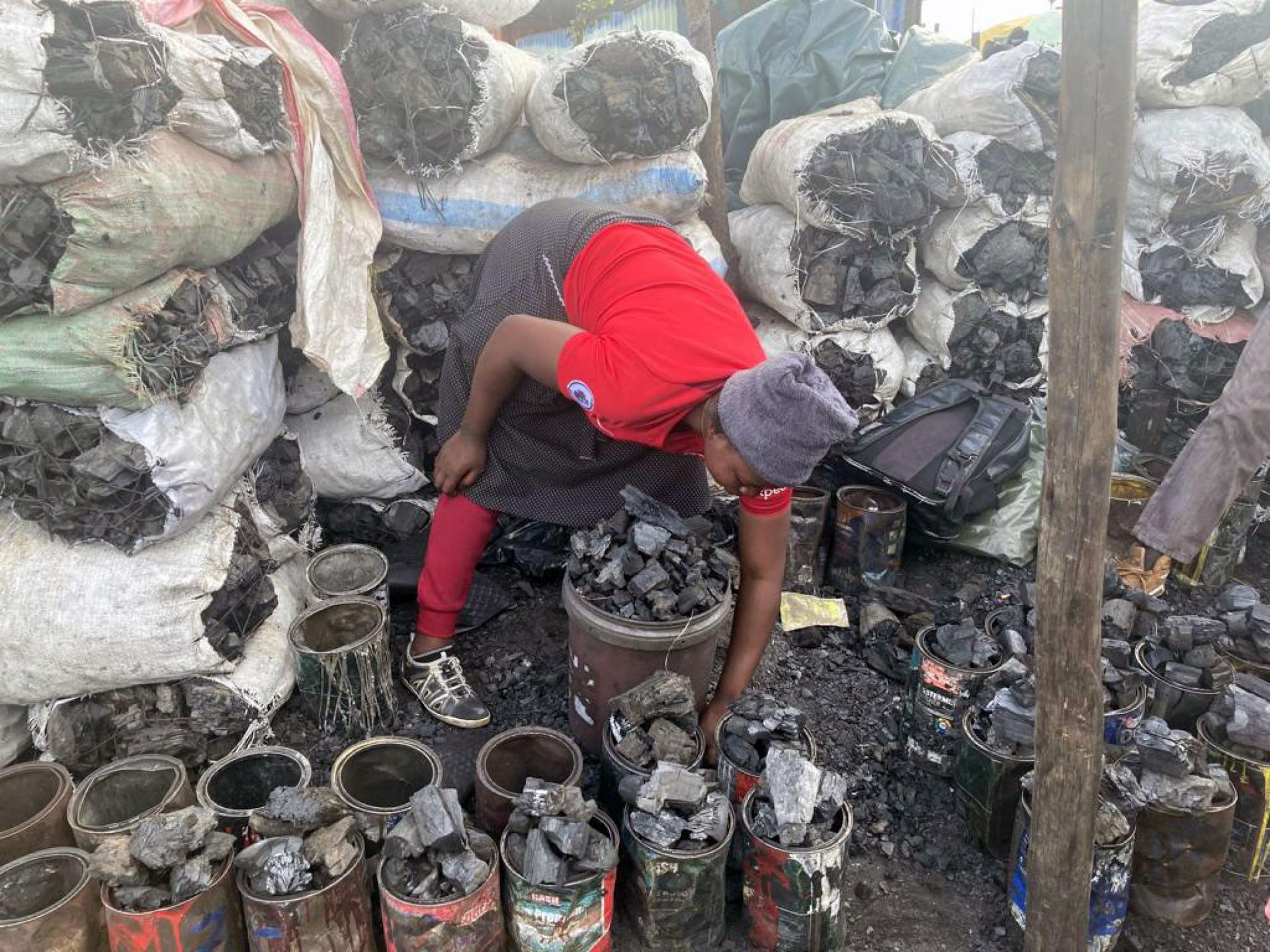 Nyarai Mupesa prepares her charcoal for sale.