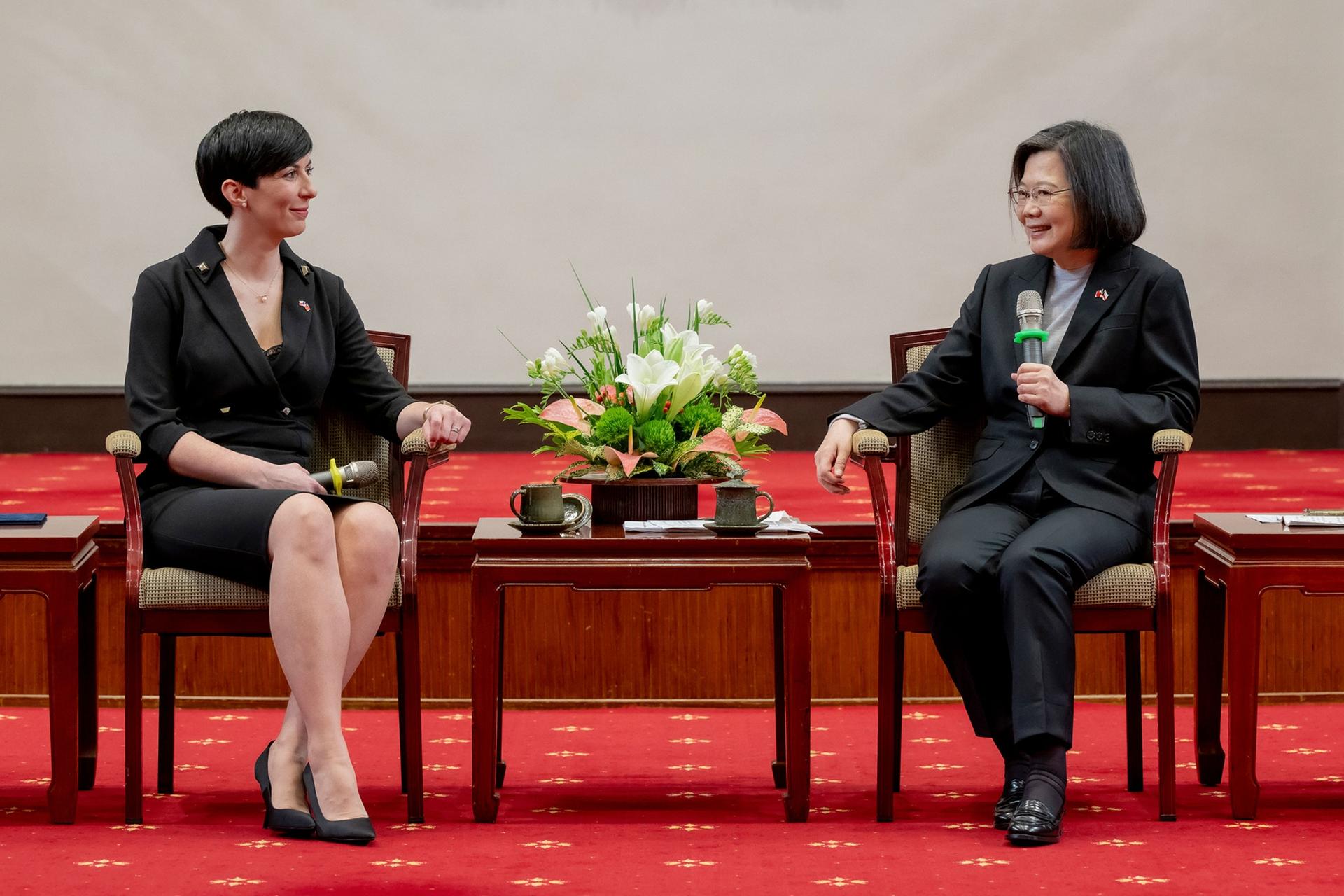 Taiwan's President Tsai Ing-wen, right, speaks with Czech Speaker of the Chamber of Deputies Marketa Pekarova Adamova on red carpeting, both wearing black suits.
