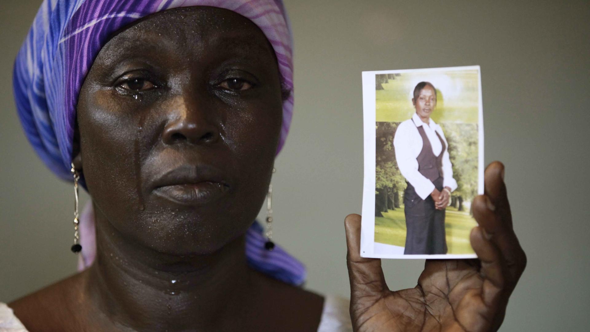 Martha Mark, the mother of kidnapped schoolgirl Monica Mark holds her daughter's photo, in the family house, in Chibok, Nigeria in May 2014. A schoolmate says Mark cried with joy when she saw a Boko Haram video appearing showing some of the kidnapped girl