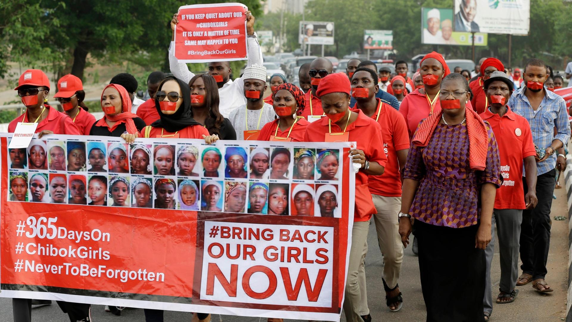 People march on a street in Abuja, Nigeria, during a silent protest calling on the government to rescue the kidnapped girls of the government secondary school in Chibok in April 2015, on the one-year anniversary of the abduction. 
