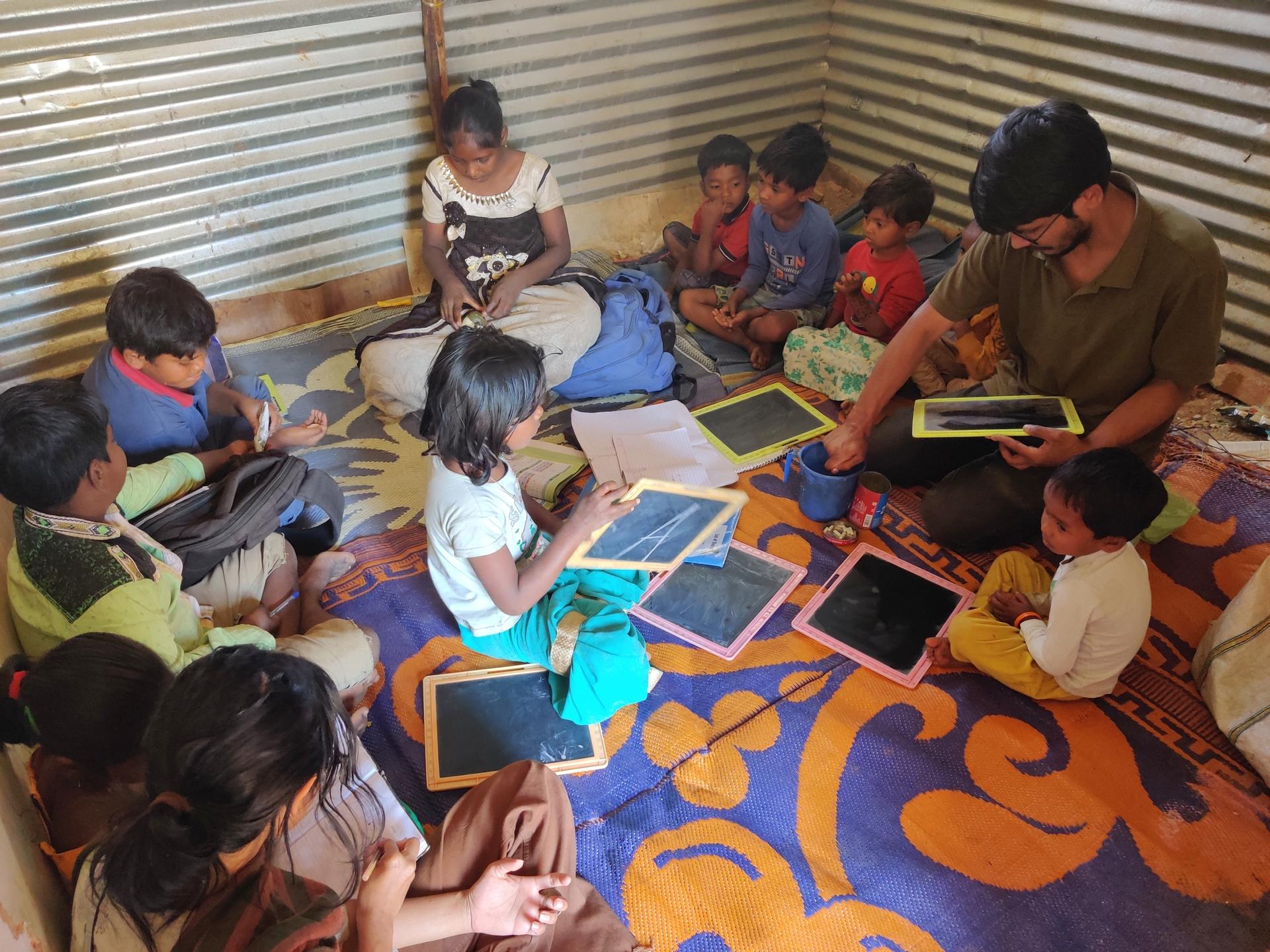 College students volunteer to teach children at an informal school in Bangalore, India.