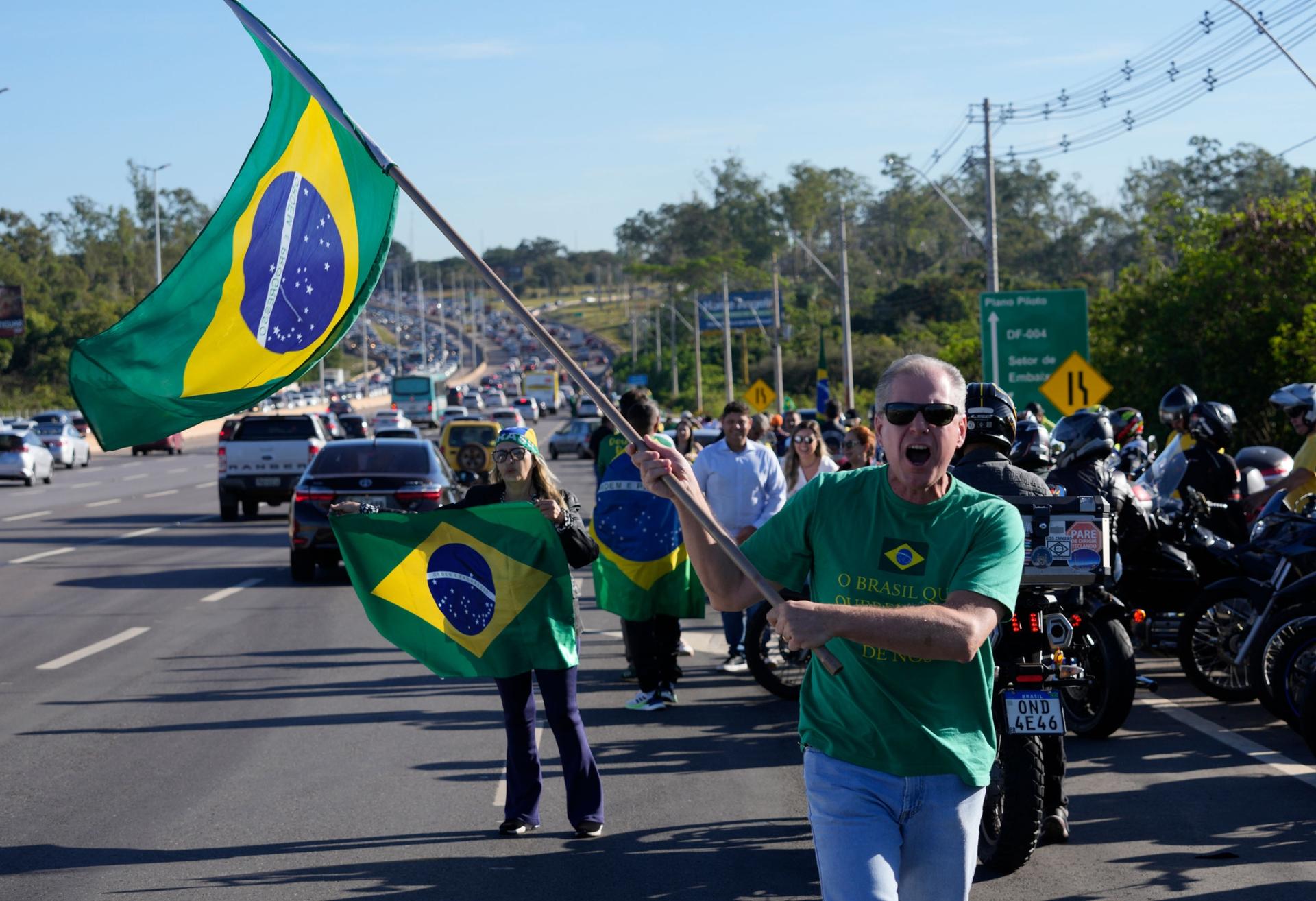 Supporters wait for the arrival of Brazil's Former President Jair Bolsonaro outside the Brasilia International Airport, in Brasilia, Brazil, Thursday, March 30, 2023. 
