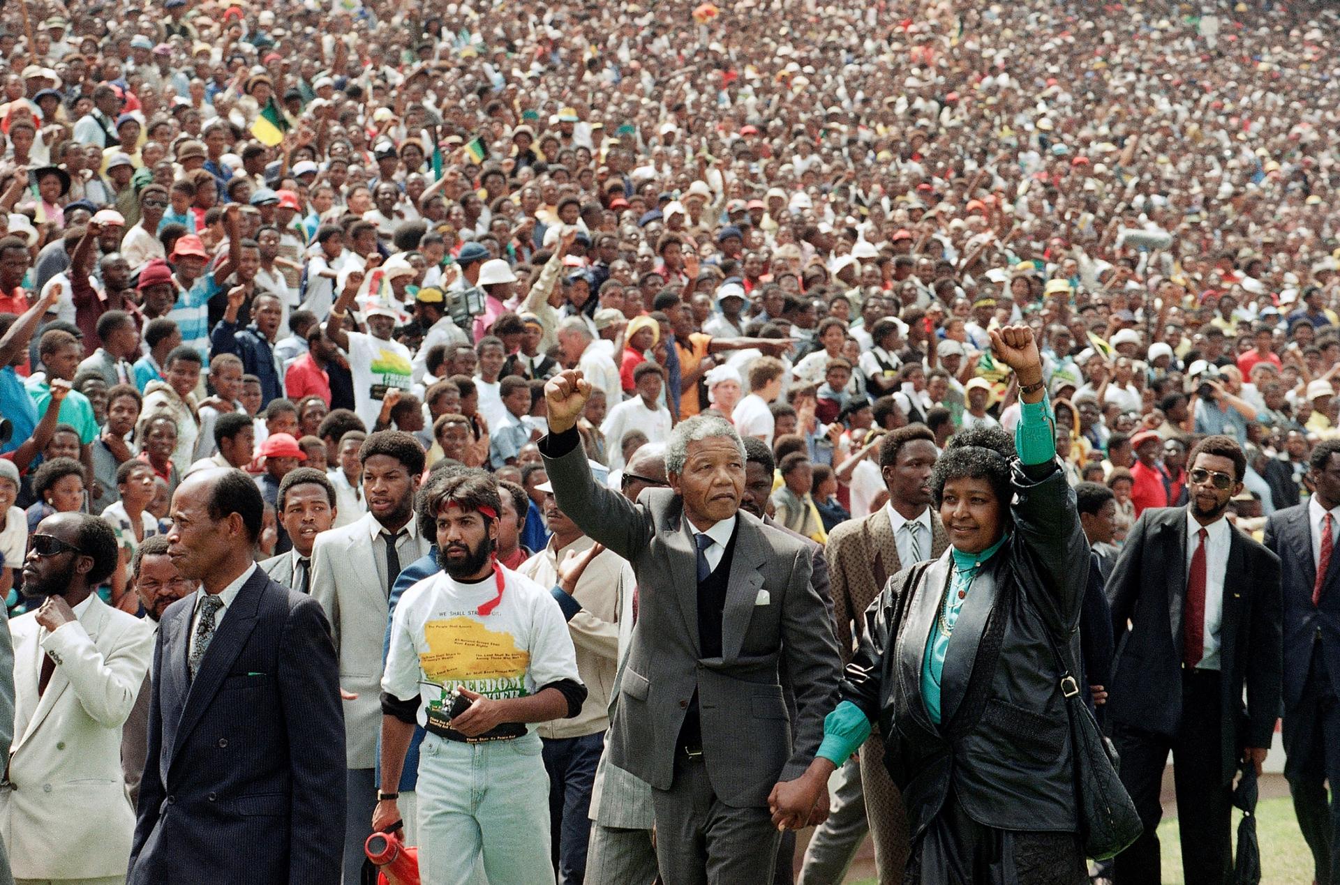 Nelson Mandela, center left, and his wife Winnie, center right, raise clenched fists as they arrive at a welcoming rally in Soweto.