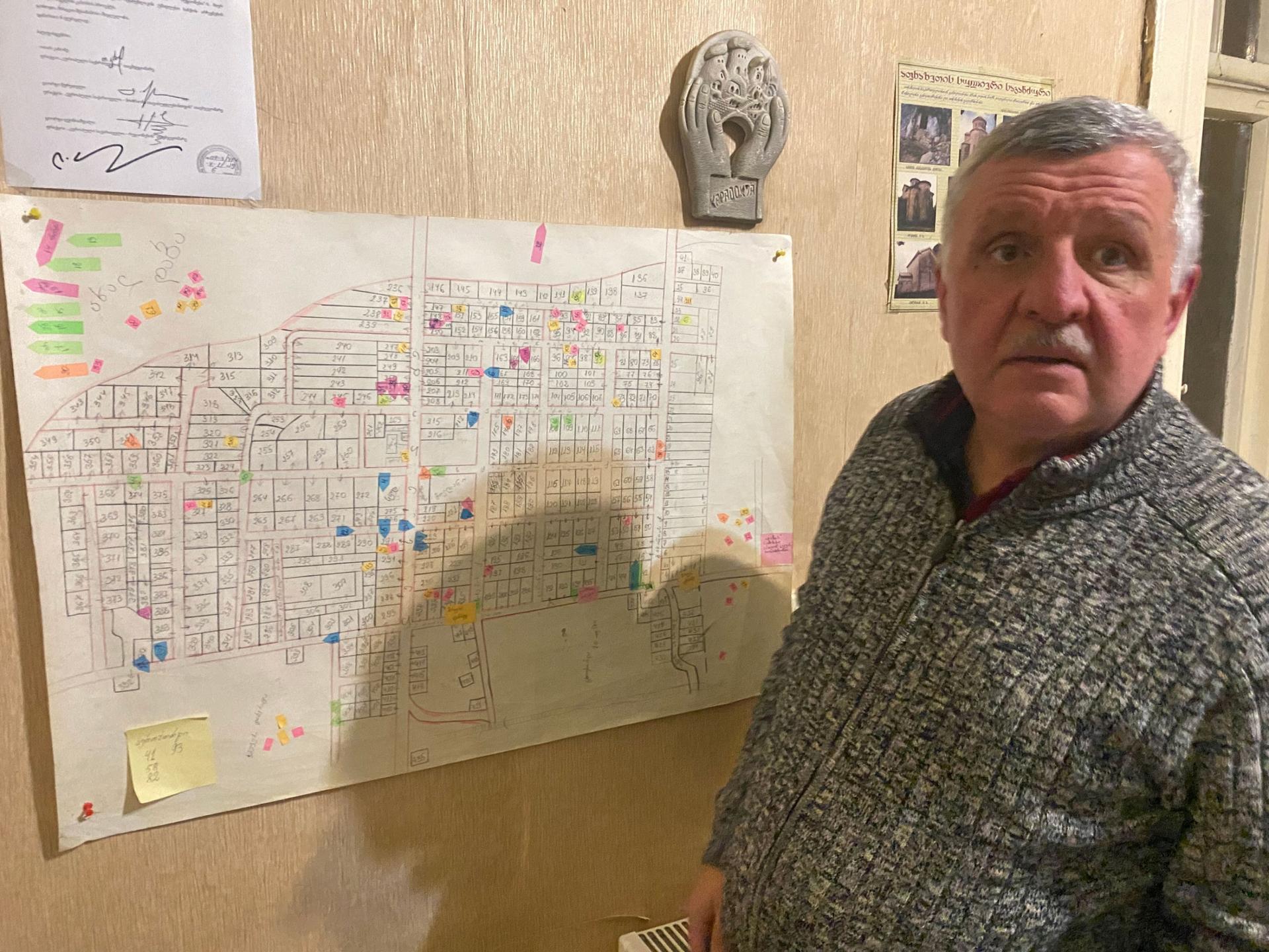 Malhaz Pataraia, a lawyer who was displaced by war in Abkhazia, Georgia, back in 1993, stands by a map of a village in Abkhazia where more than 100 Georgians were killed during the war. 