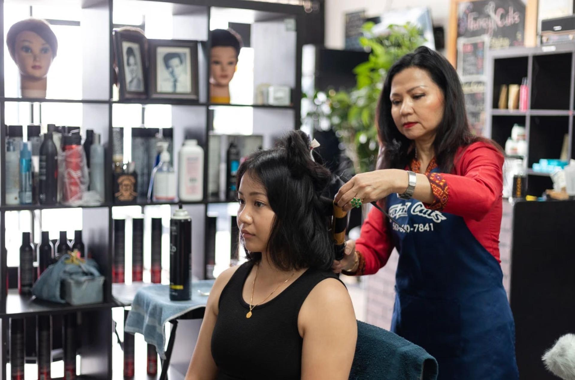 Ariya Tok prepares for her graduation ceremony by getting her hair done by her mother Dannaly Tok.