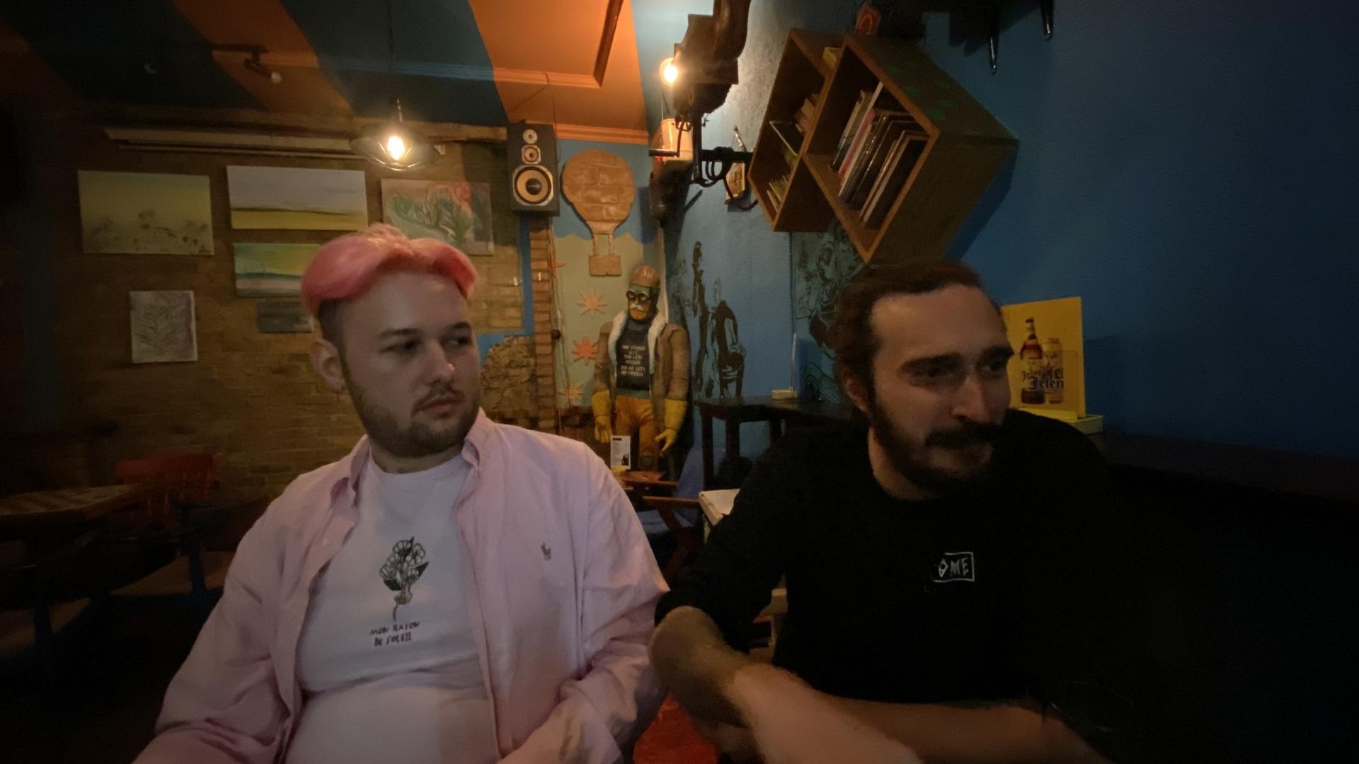 two men sit next to each other at a bar