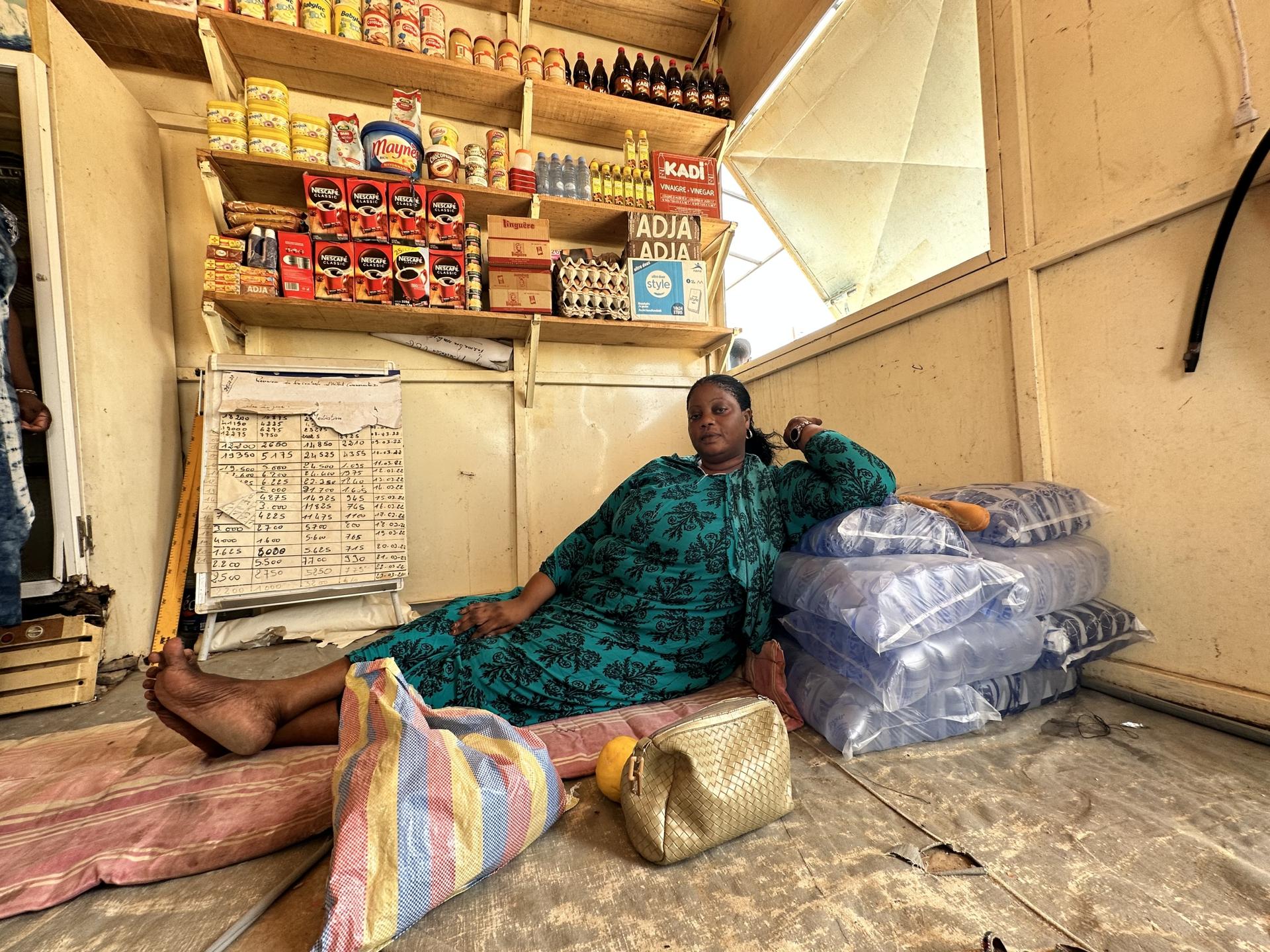 Sailo Boufal, a mother at the displacement camp who says she and her kids miss the beachside, lies down on the floor of a grocery shop where she works.