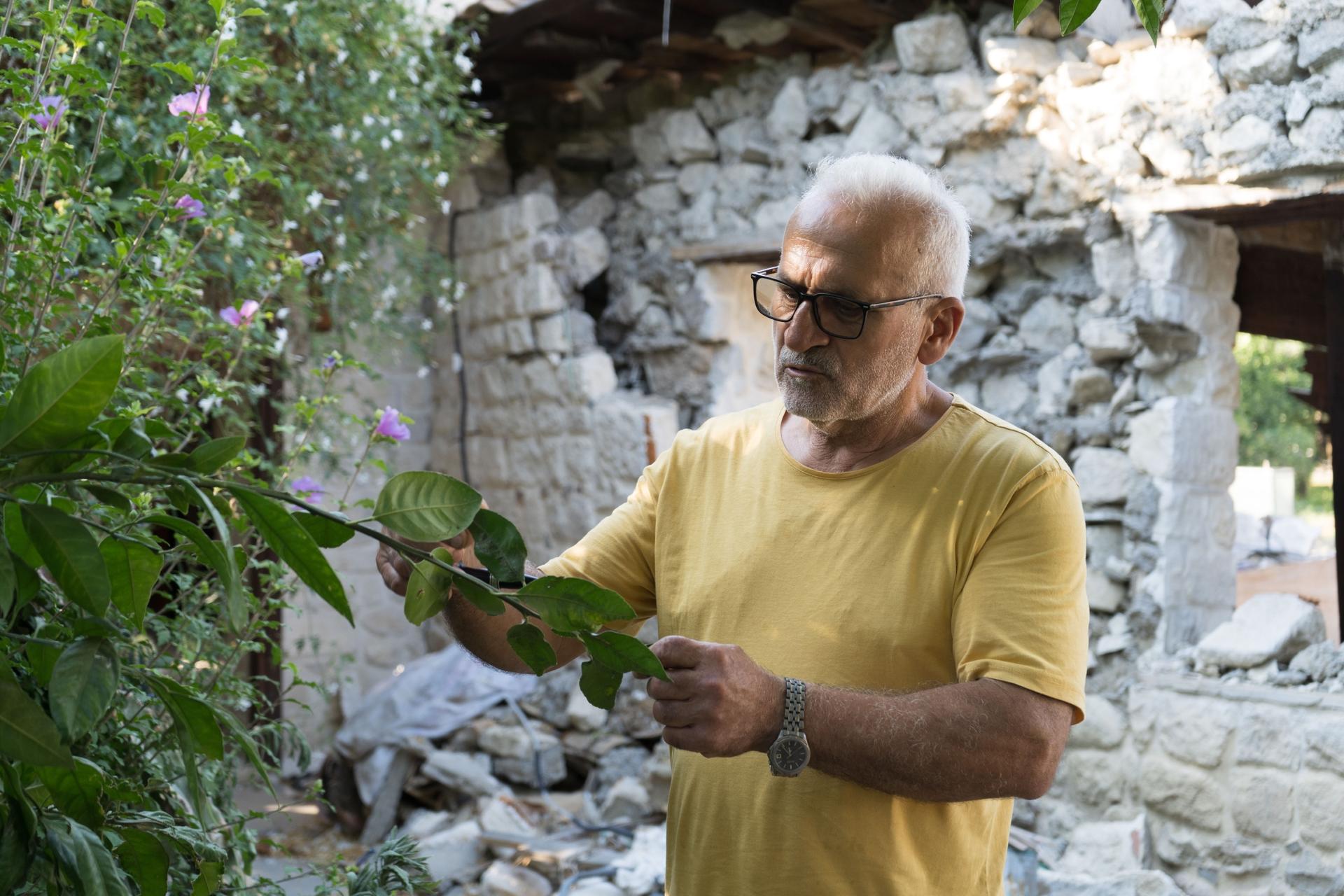 Mişel Atik, director of the Samandağ Environmental Protection and Tourism Association, stands outside the ruins of the historic house that he had painstakingly restored. 