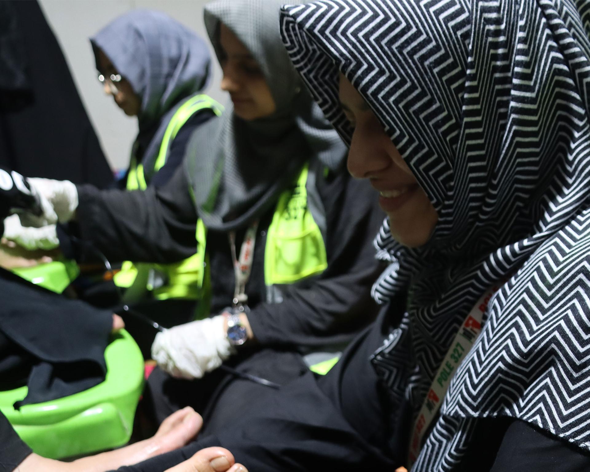 Women volunteers give free foot massages to those participating in the Arbaeen walk, September 2023.