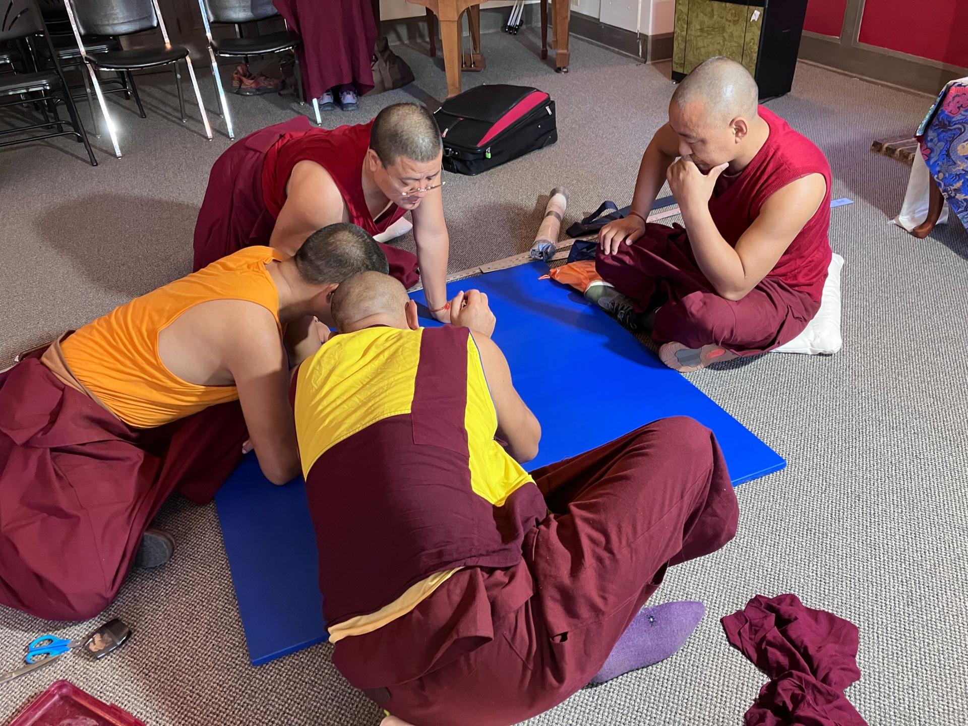 The monks contemplate their design on day one of the process. 