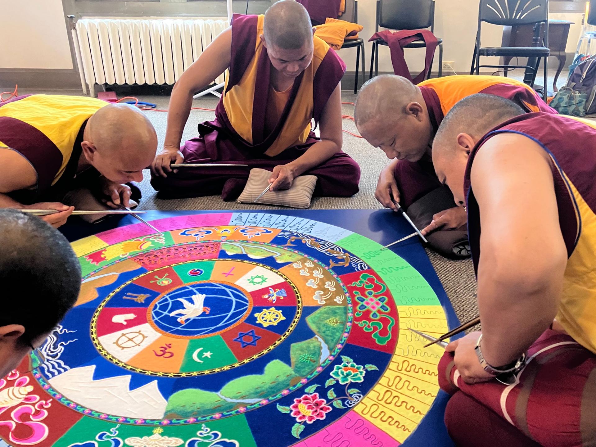 The monks work quickly with focus to make the final touches on the mandala on the last day, when it will then be ceremoniously dissolved.