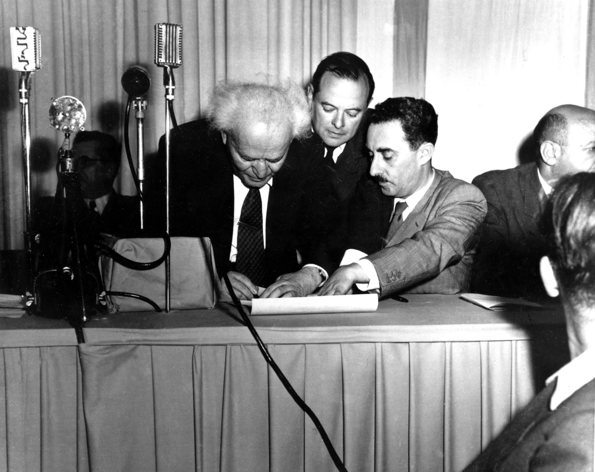 Israeli Prime Minister David Ben Gurion, left, signs a document in Tel Aviv proclaiming the new Jewish State of Israel, May 14, 1948.