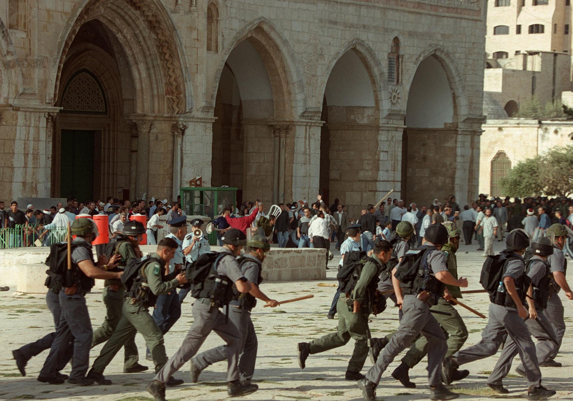 Israeli troops run as clashes erupt outside the Al-Aqsa mosque compound in Jerusalem's Old City, following a visit to the holy site by Israeli right-wing opposition leader Ariel Sharon, Sept. 28, 2000,