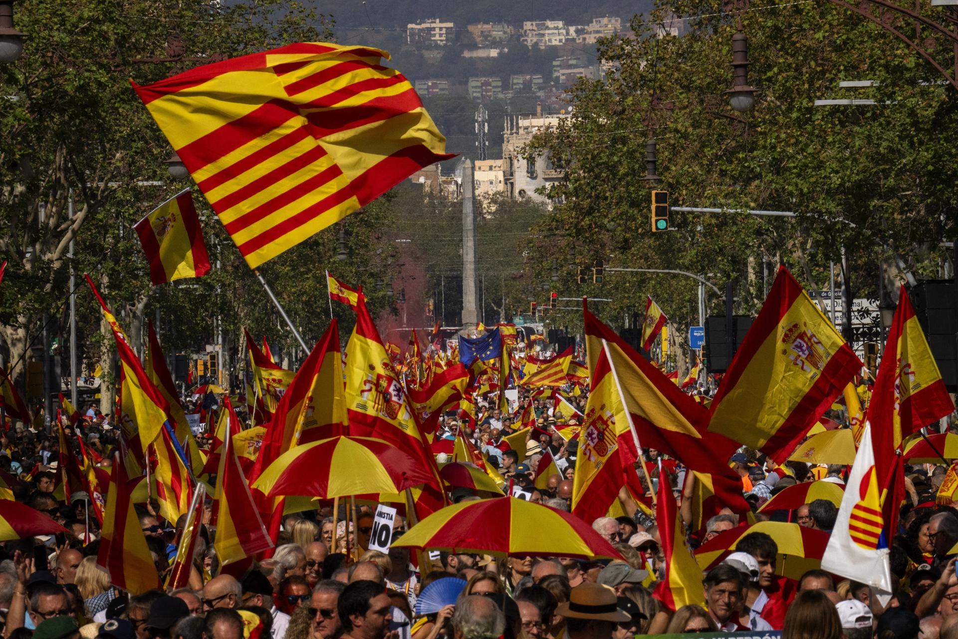 large crowd marching with flag of Spain