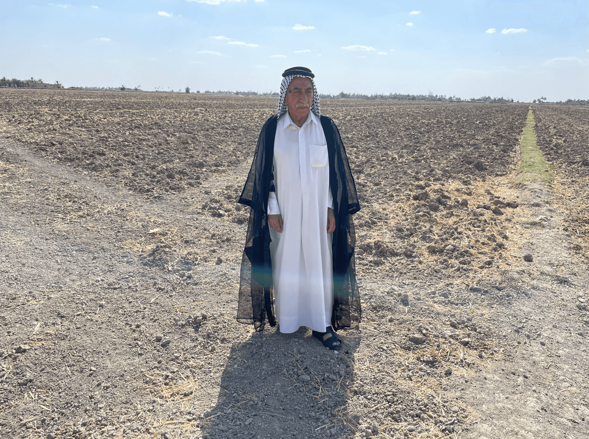 Salah Fareeq Al-Feroun standing on his farm that is now dry and barren, Al-Meshkhab, Iraq, Aug. 30, 2023.