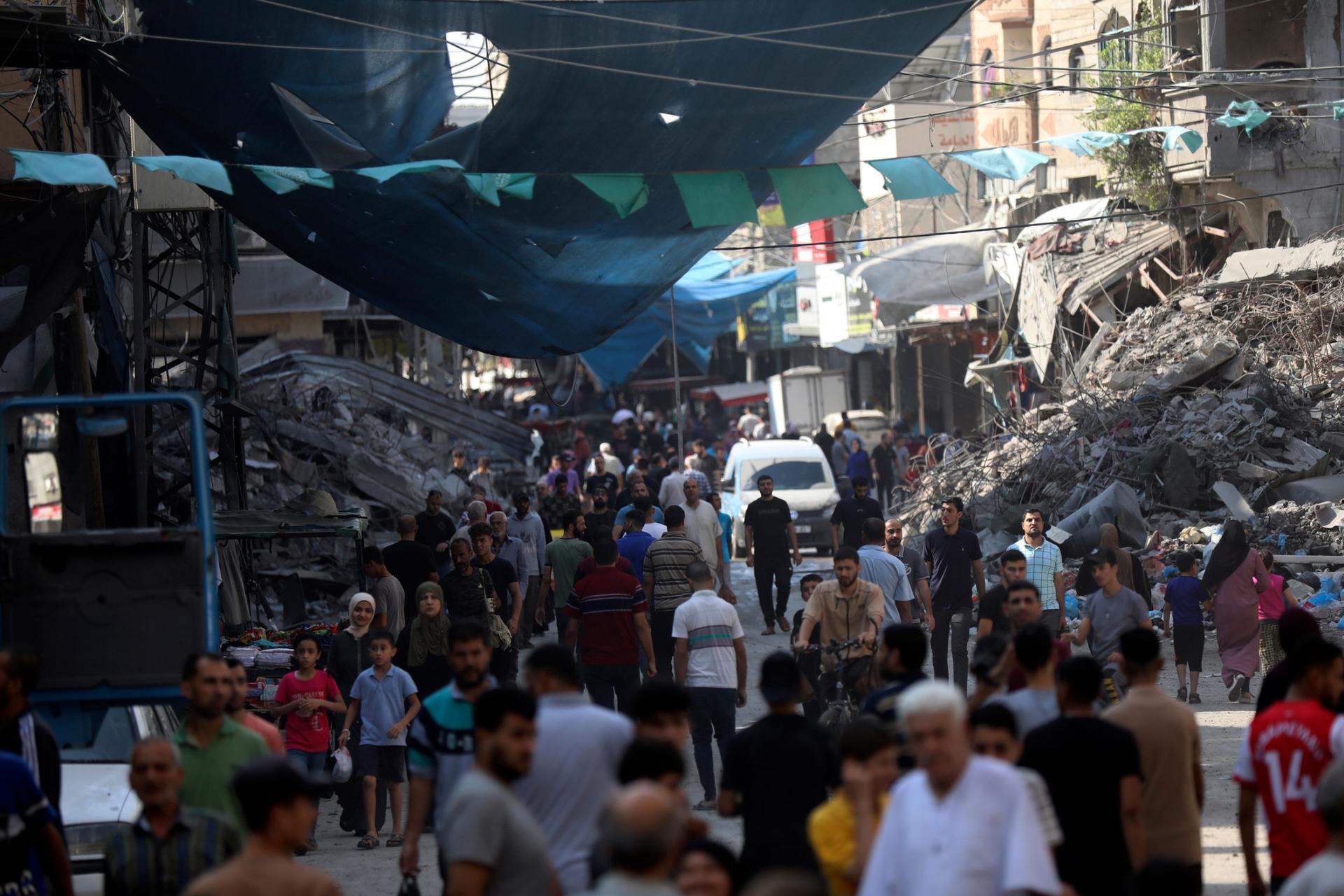 Palestinians walk in the street market of Jabaliya refugee camp, northern Gaza Strip, Wednesday, Nov. 1, 2023, after an Israeli airstrike. 