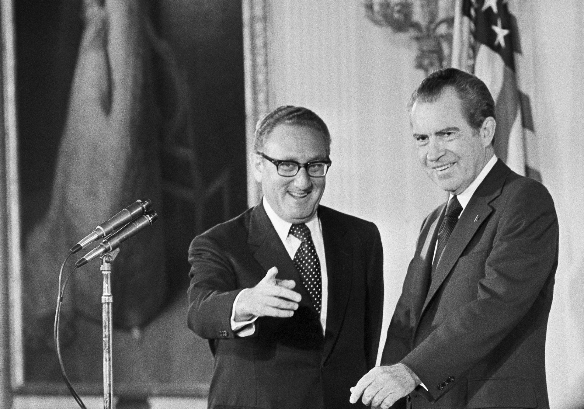 Secretary of State Henry Kissinger, left, gestures to the audience in the East Room of the White House, Sept. 22, 1973, as President Richard Nixon watches, in Washington. Kissinger had just been sworn in as the 56th secretary of state. 