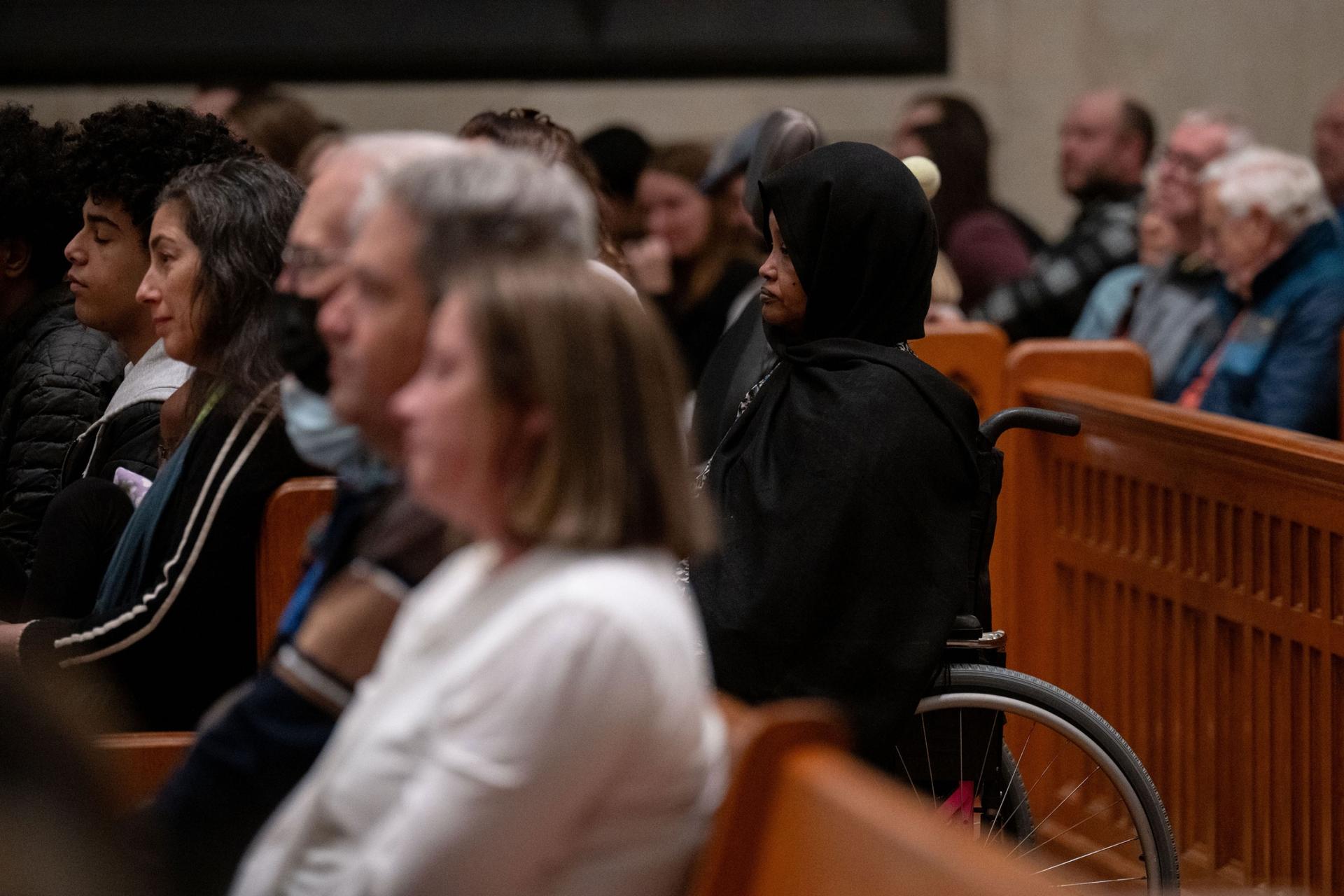 Fowsia Musse, executive director of Maine Community Integration, listens to speakers during the OneLewiston Community Vigil in the Basilica of Saints Peter and Paul in Lewiston, Maine, on Sunday, Oct. 29, 2023. 