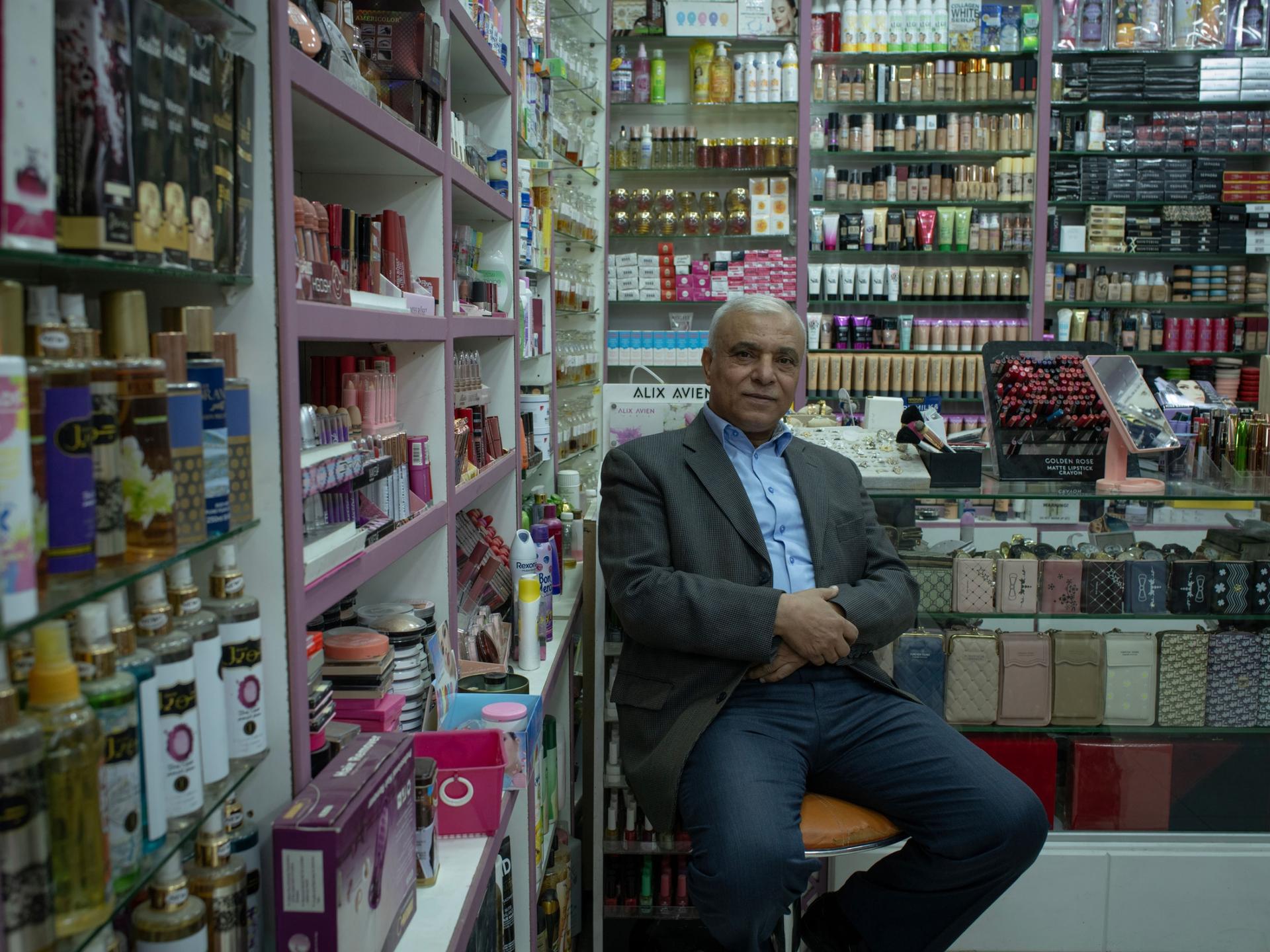 Hussein Abdullah, owner of a cosmetic shop, poses for a picture at his shop at the Baqa'a refugee camp, north of the capital Amman.
