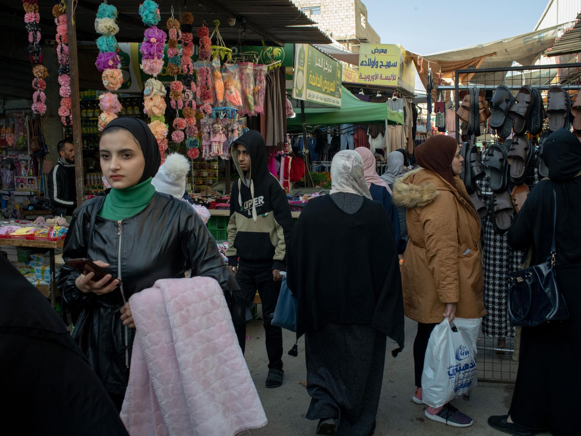 People walk at a market at the Baqa'a refugee camp, north of the capital Amman, Dec. 12, 2023.