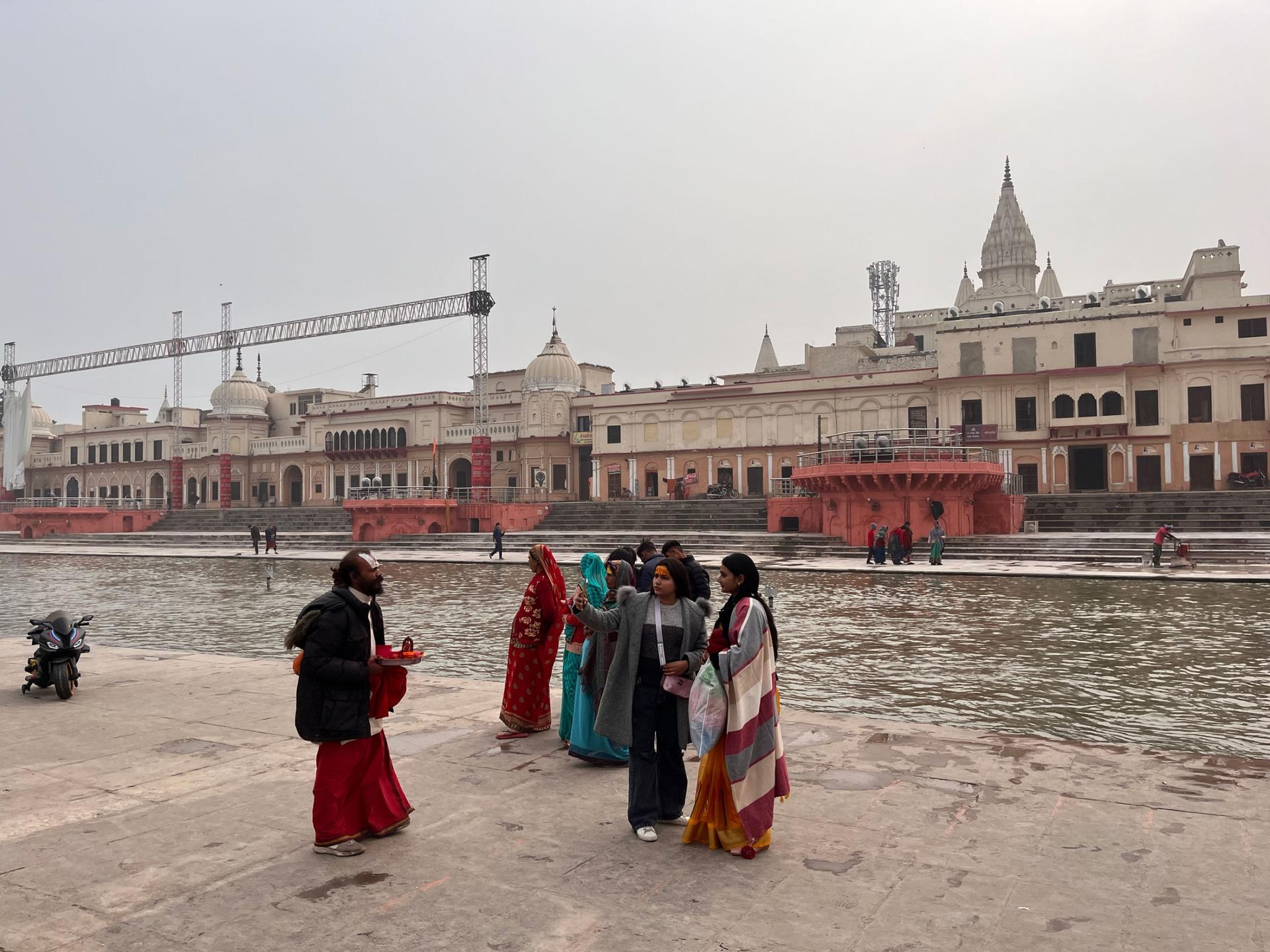  Tourists take selfies on the banks of the Saryu river in Ayodhya as Hindu pilgrims take a holy dip.