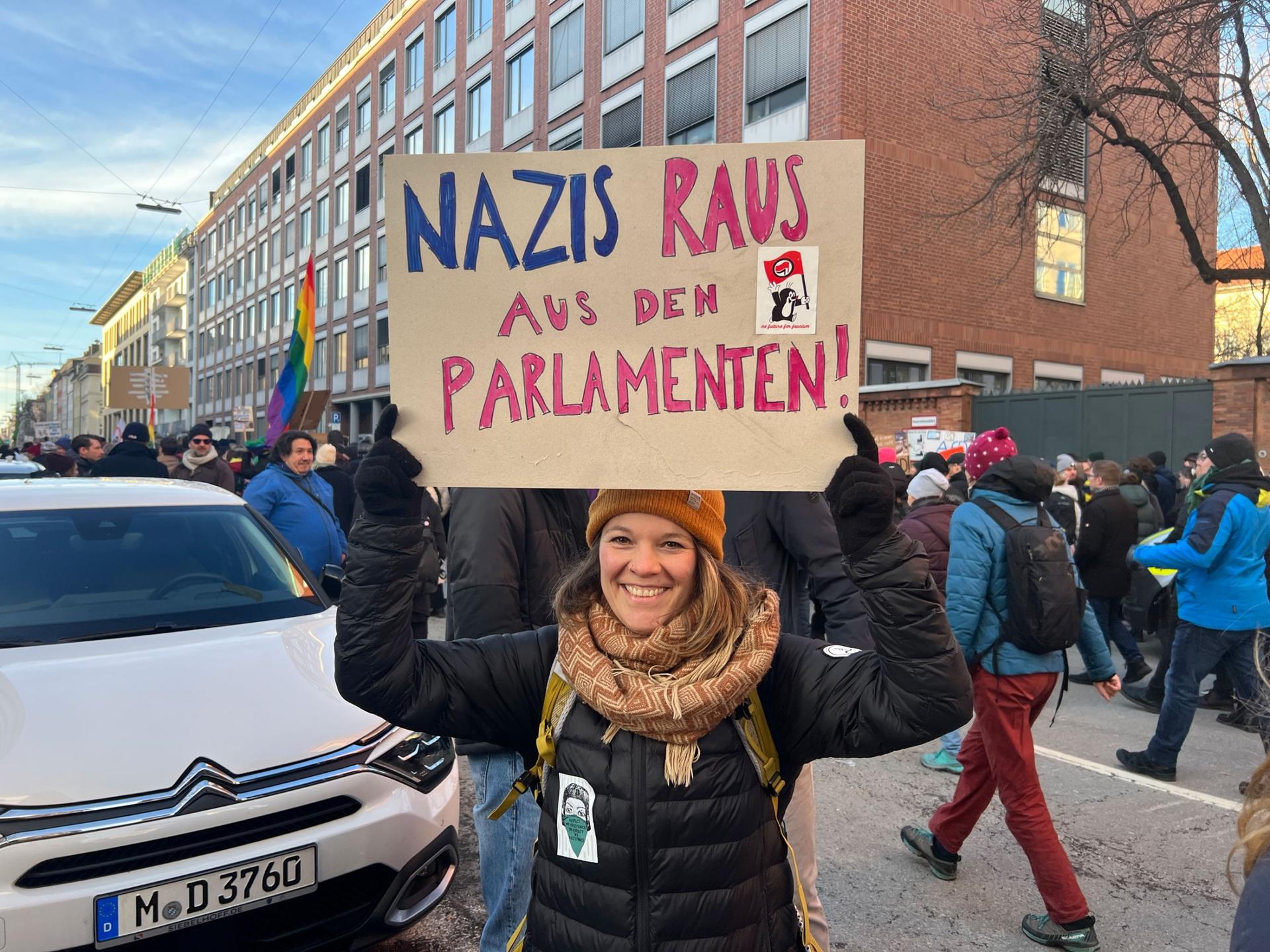 Demonstrator Karolina, 34, holds up a sign her and her friends carried at a mass protest against growing far-right influence in Germany, held in Munich on Jan. 21, 2023. 
