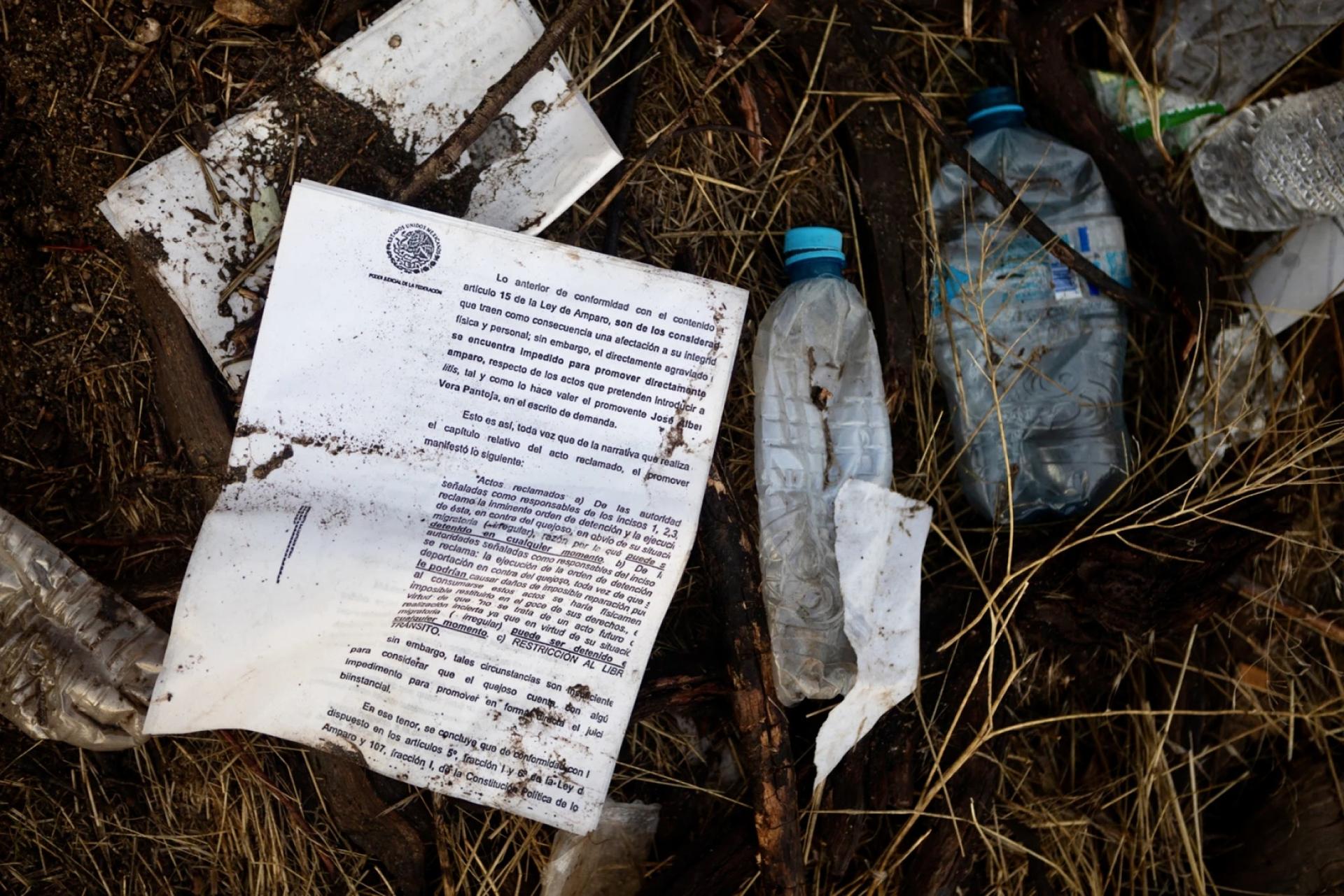 Among water bottles and food wrappers discarded papers detailing Mexican immigration laws are shown.