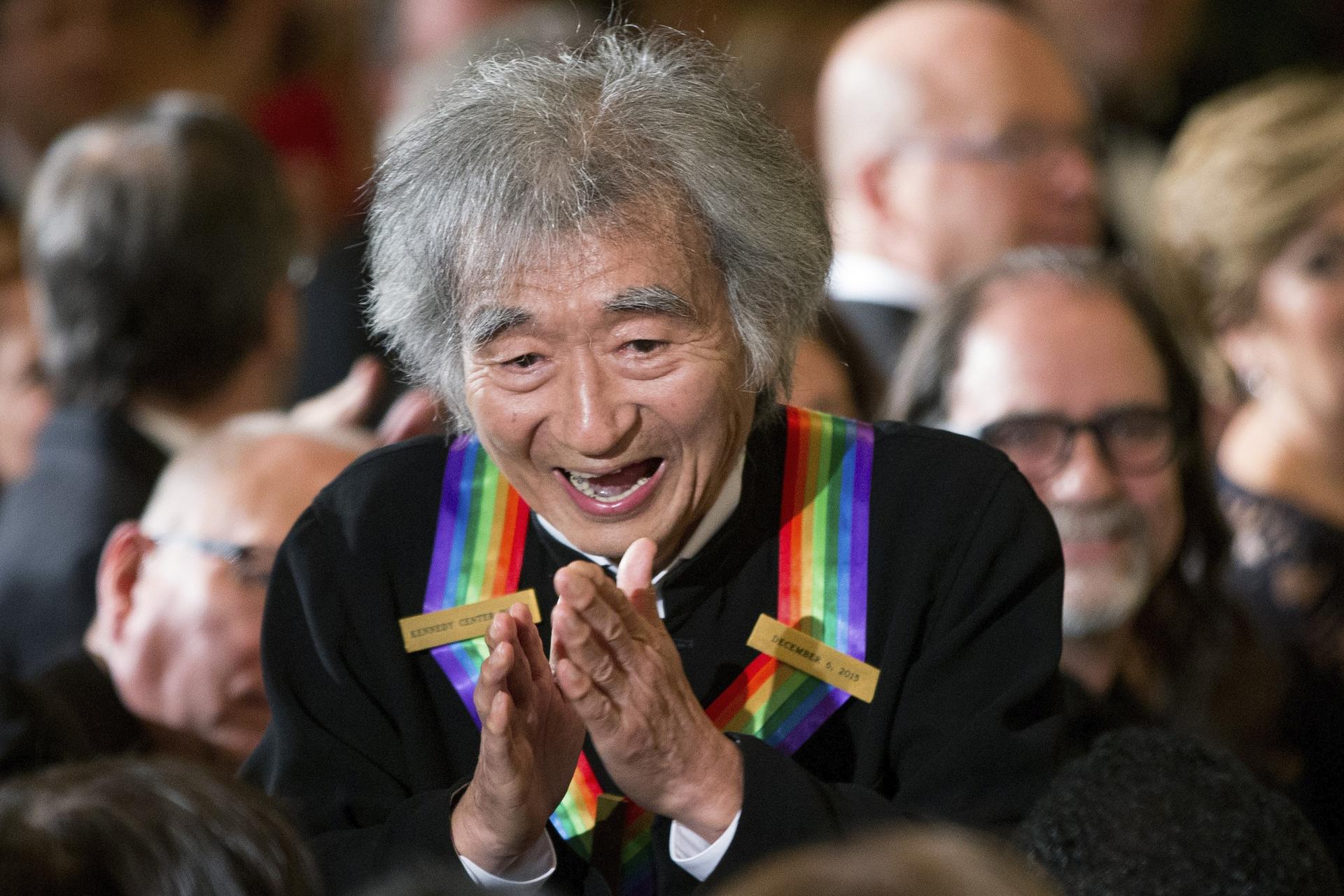 Conductor Seiji Ozawa stops to greet a young child in the audience as he arrives for a reception for himself and the other Kennedy Center Honors honorees in the East Room of the White House in Washington, Dec. 6, 2015.