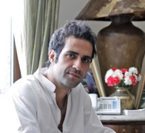 A portrait of author Aatish Taseer wearing a white shirt