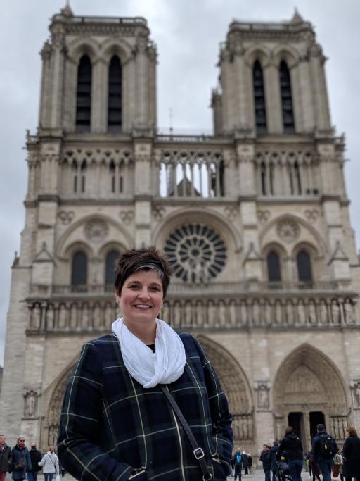 A woman poses for a photo in front of Notre-Dame's towers
