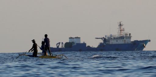 Two Filipino fishermen fish near large Chinese vessel in disputed waters